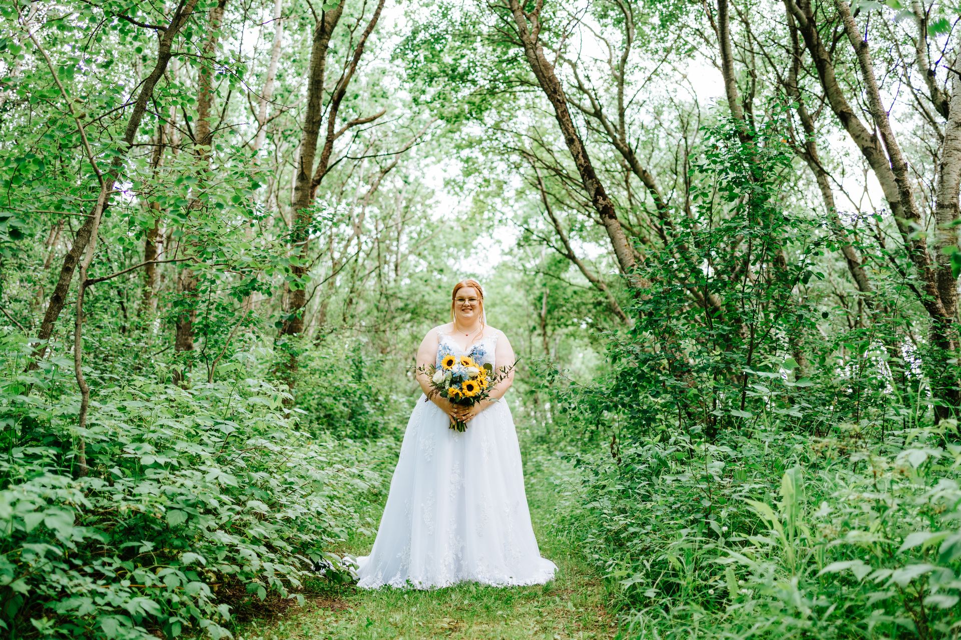 Guests seated on white benches waiting for the ceremony to begin in the birch forest at Deer Meadow Farm Manitoba