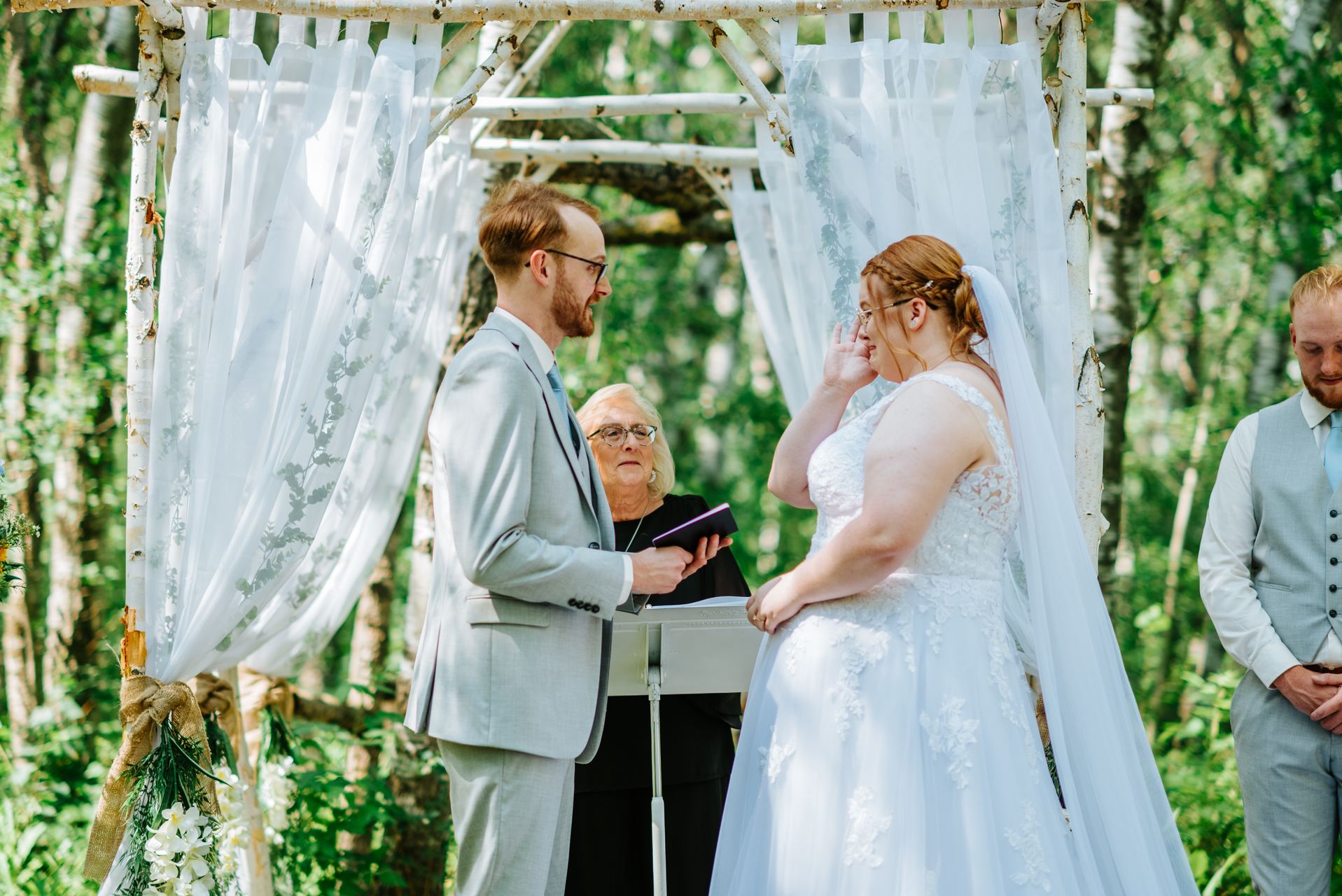 Closeup of couple during vows at the log arbor at Deer Meadow Farm — Manitoba wedding photographer Chris Ngo