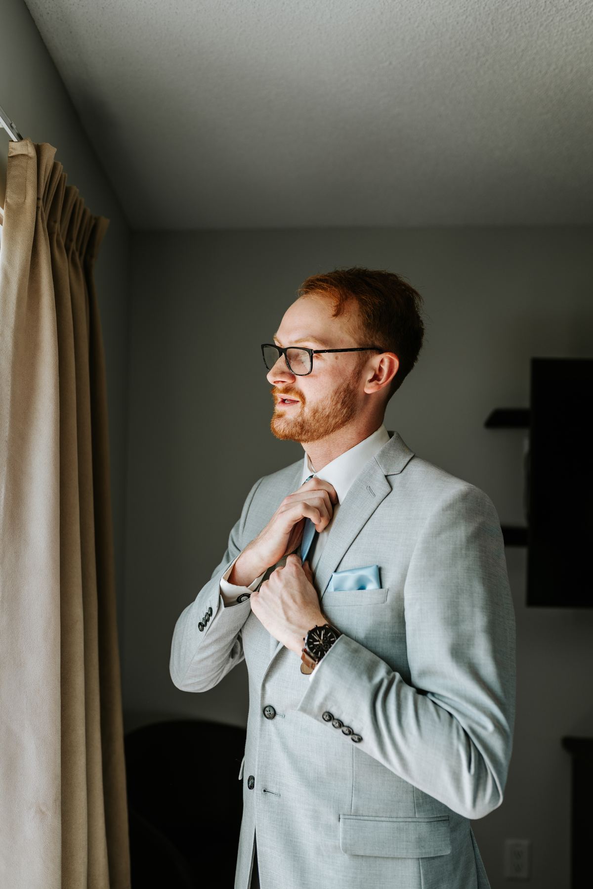 Groom Josh in light grey three-piece suit and blue tie ready for wedding day — Deer Meadow Farm Manitoba