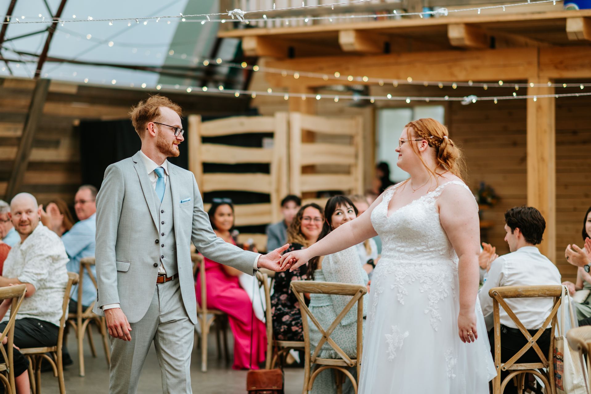 Quonset barn reception interior with string lights at Deer Meadow Farm Manitoba wedding by Ngo Photography