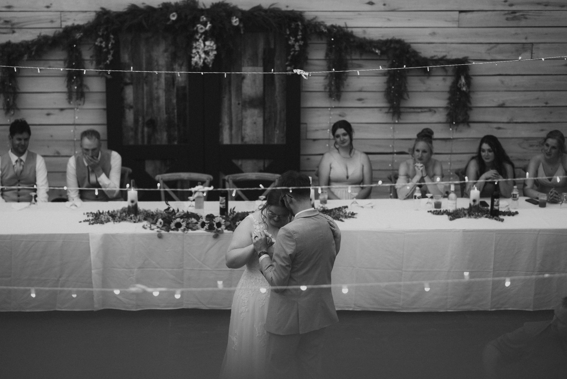 Sunflower centrepieces on reception tables in the quonset barn at Deer Meadow Farm Manitoba wedding