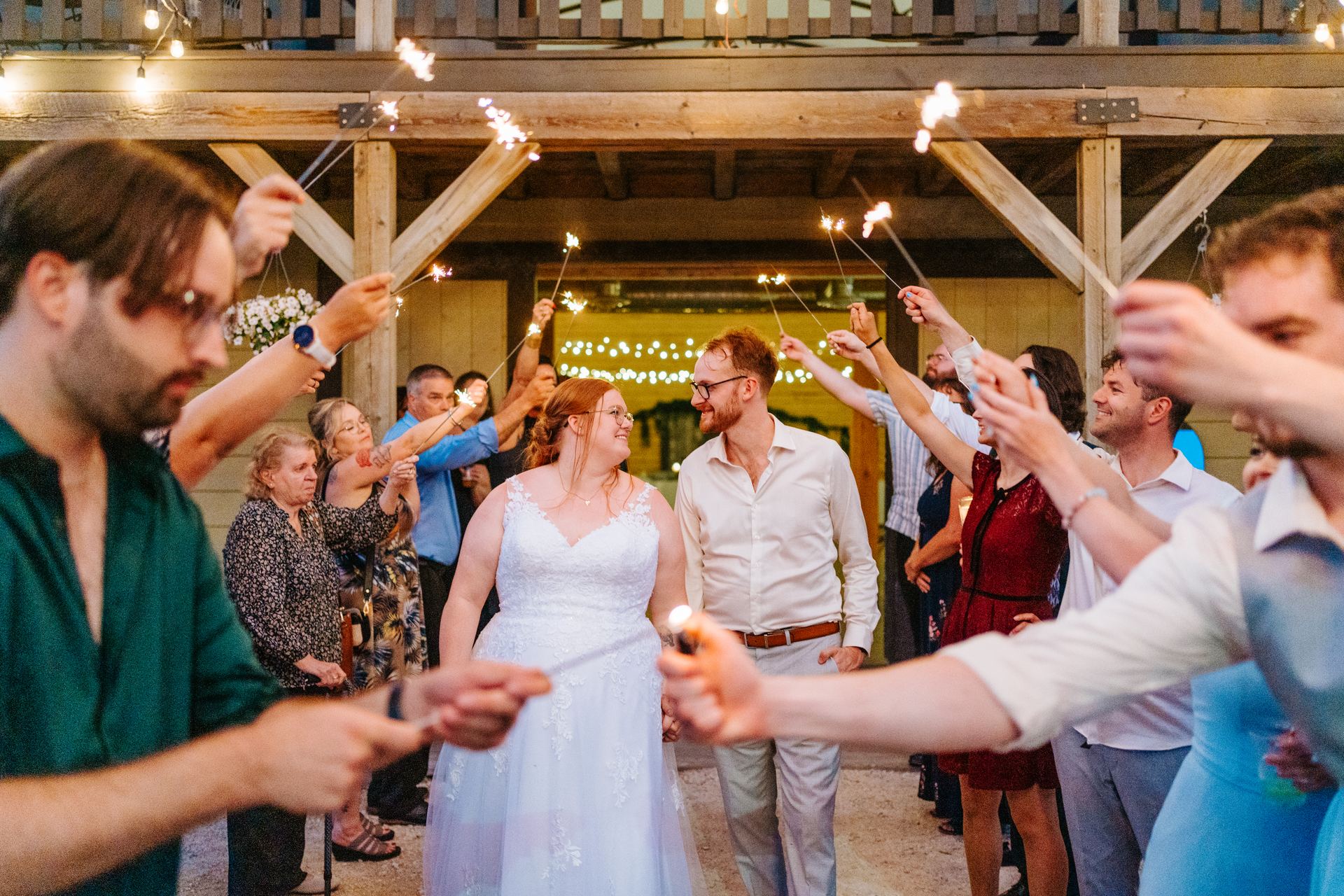 Sparkler exit send-off at the quonset barn entrance — guests lining the path holding sparklers at Deer Meadow Farm Manitoba wedding