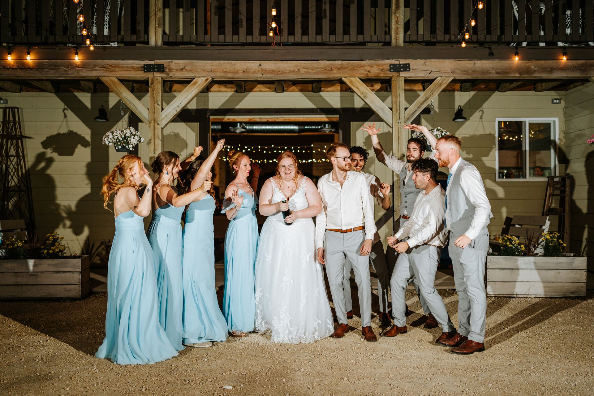 Wedding party champagne send-off outside the quonset barn at night — Deer Meadow Farm Manitoba wedding