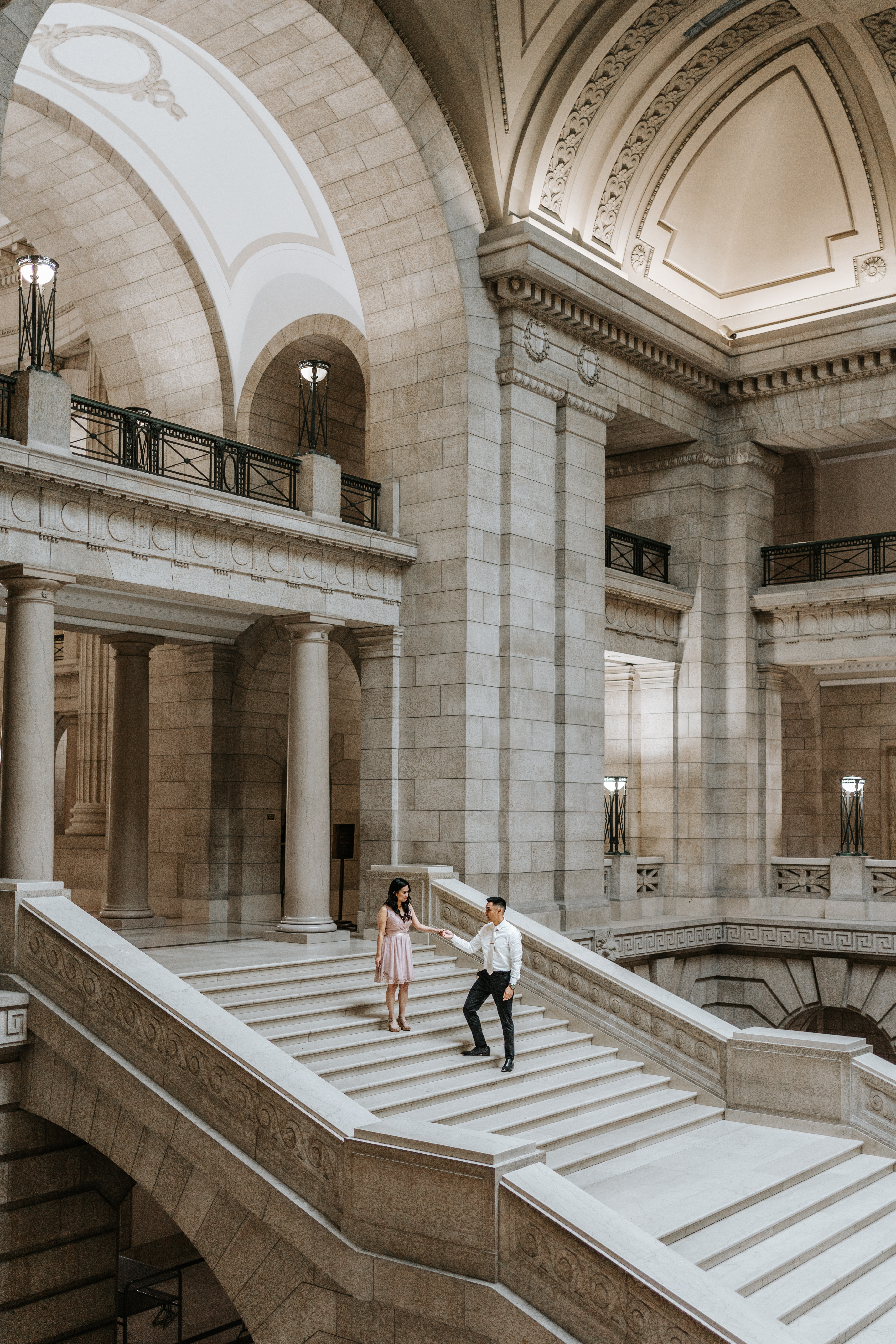 Couple on grand staircase Manitoba Legislative Building engagement session Winnipeg — Ngo Photography