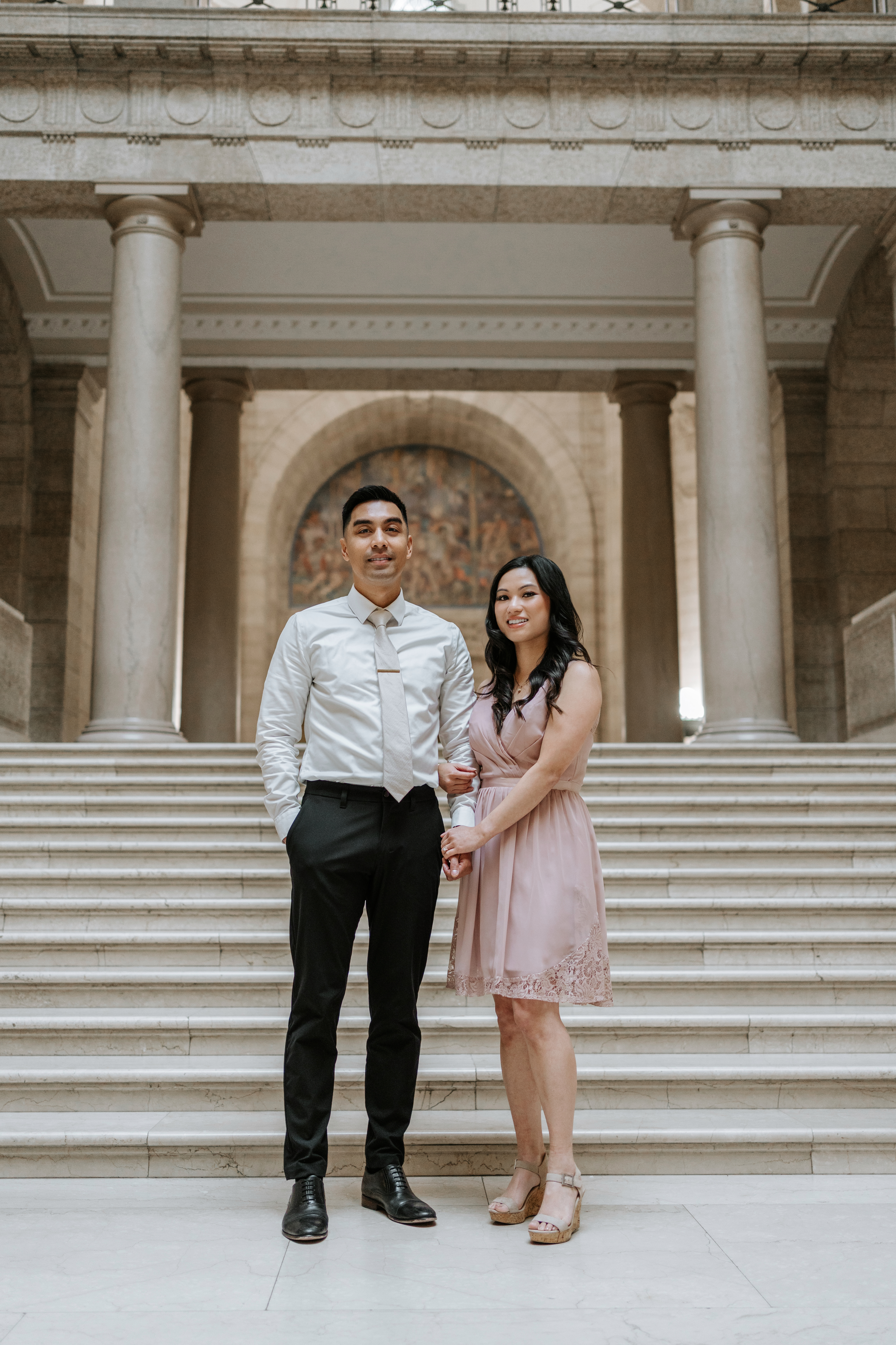 AJ and Julie couple portrait at the bottom of the grand staircase inside the Manitoba Legislative Building Winnipeg — engagement photography by Ngo Photography