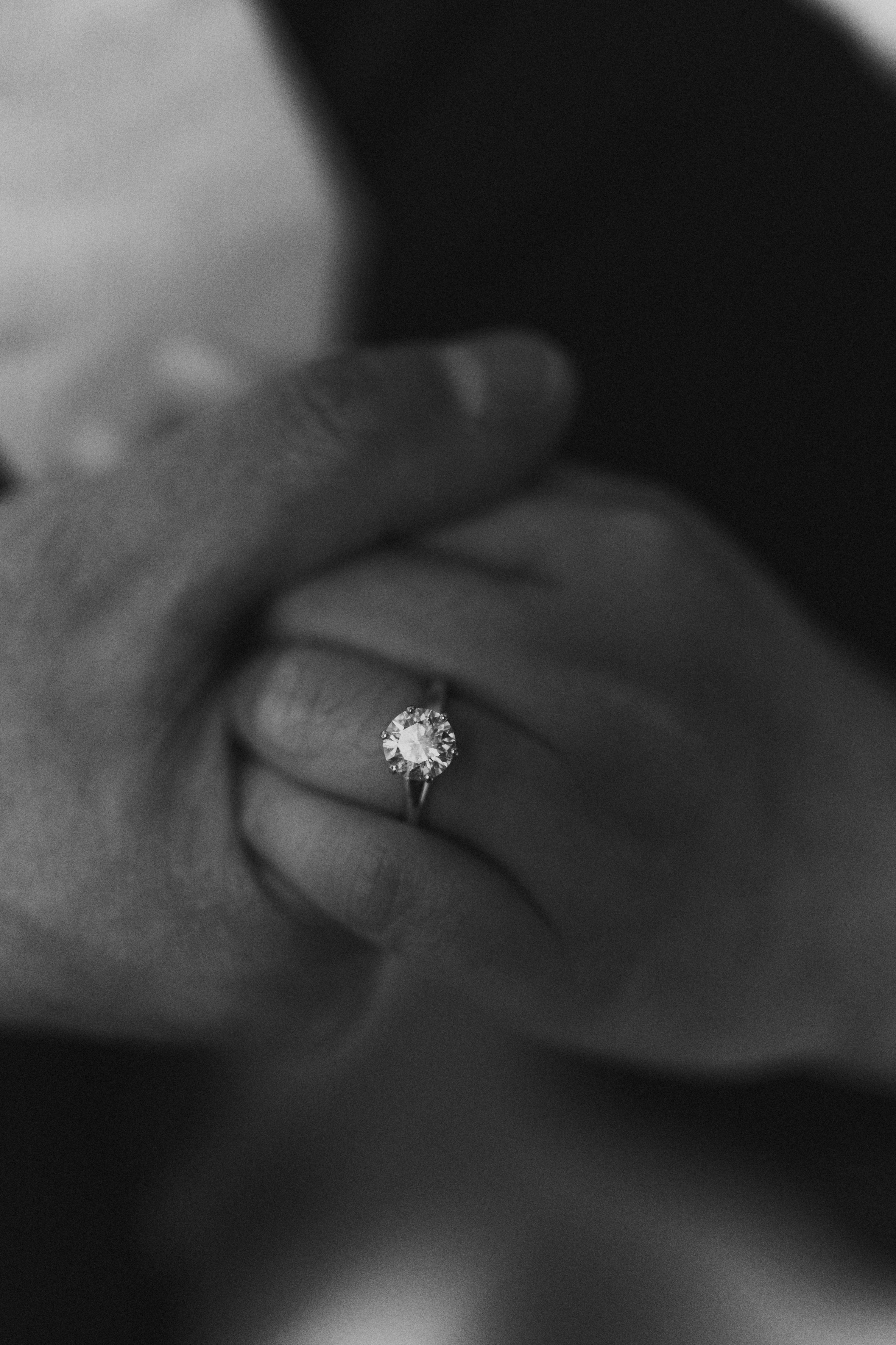 Black and white engagement ring detail shot of Julie's ring with AJ holding her hand at the Manitoba Legislative Building Winnipeg — Ngo Photography