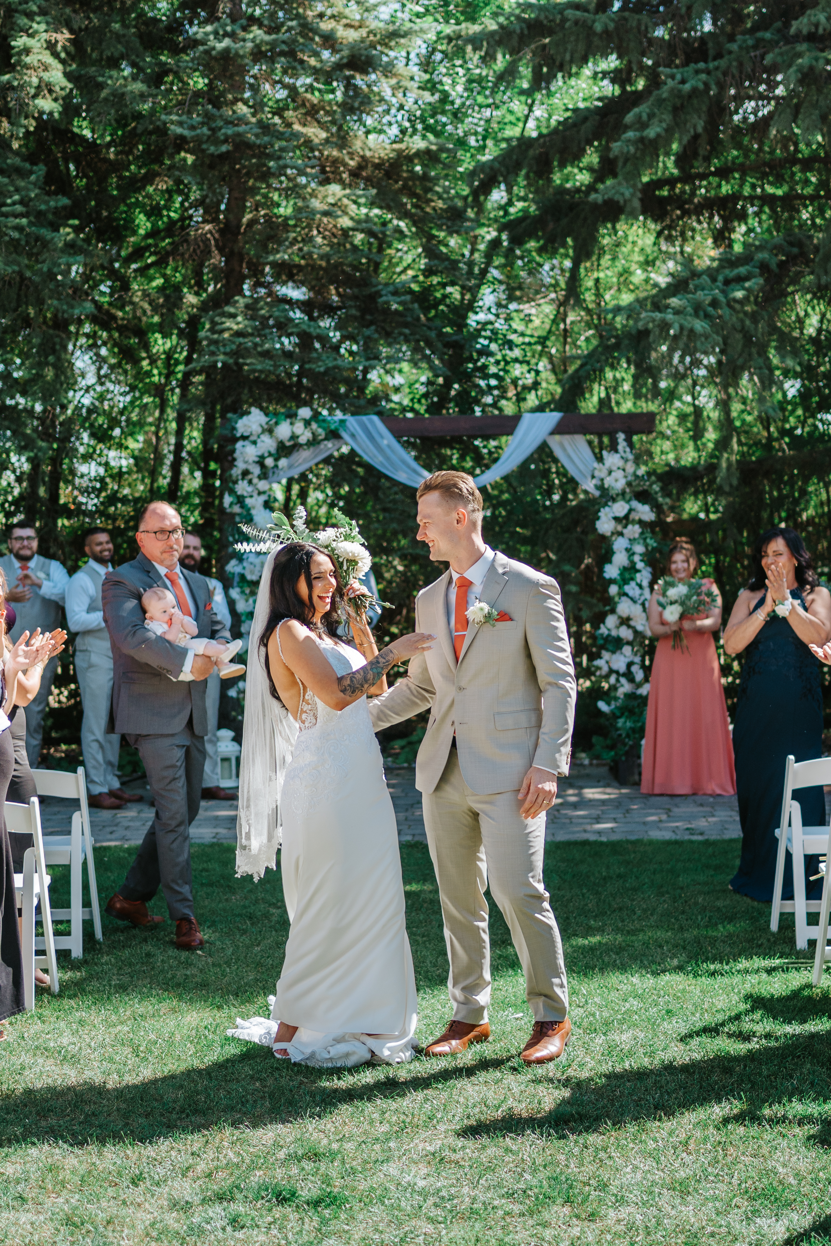 Brandon and Selena walking back down the aisle as husband and wife at Ashgrove Acres with guests applauding — Winnipeg wedding photographer Chris Ngo