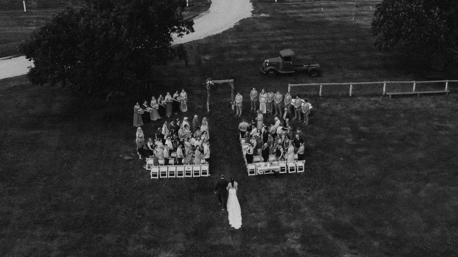 Drone aerial of the ceremony at Pelican Yacht Club, Pelican Lake visible behind the arbor — Ninette, Manitoba wedding