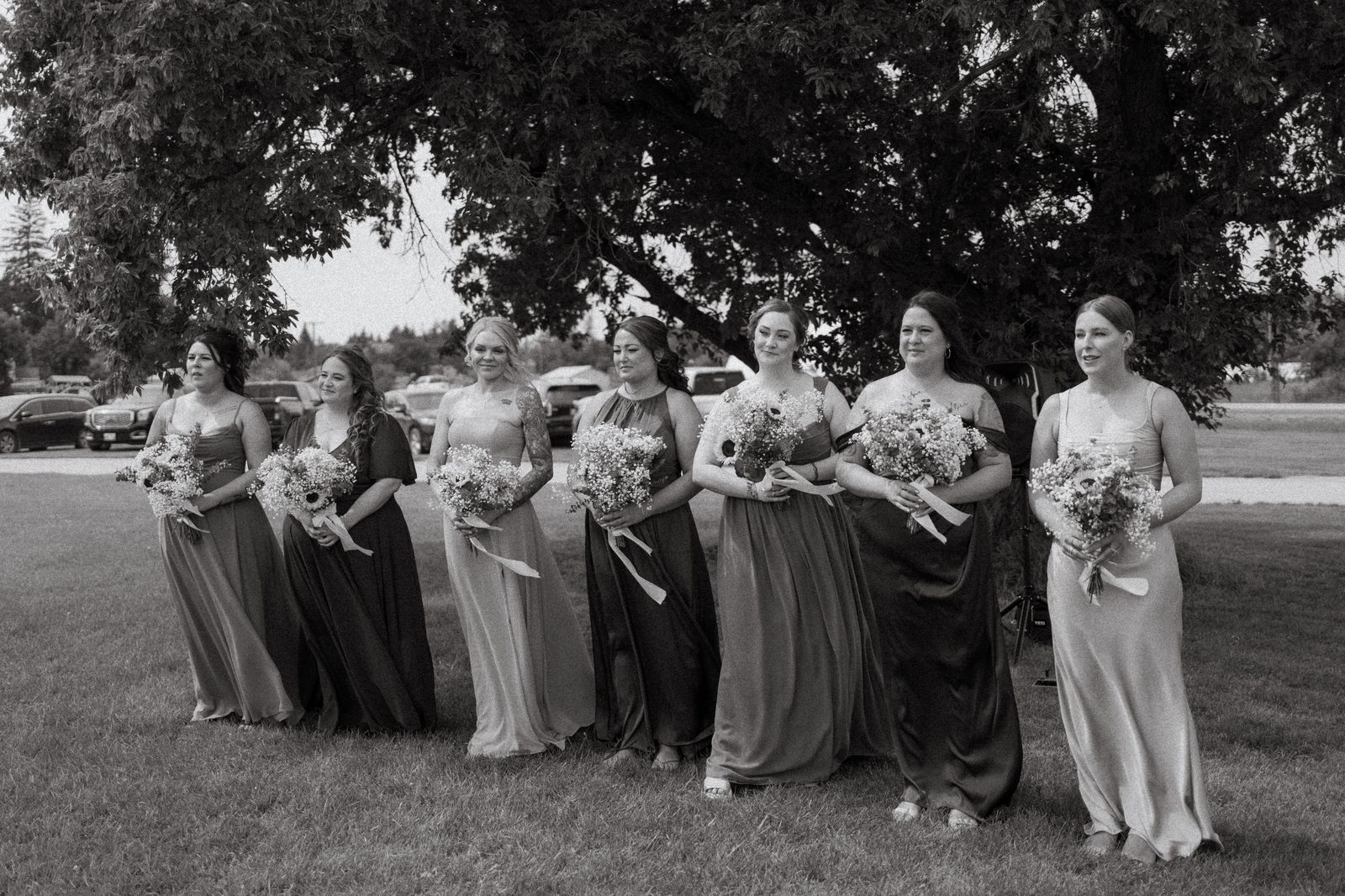 Bridesmaids in sage and green gathering under the oak tree, black and white — Pelican Yacht Club wedding, Ninette, Manitoba