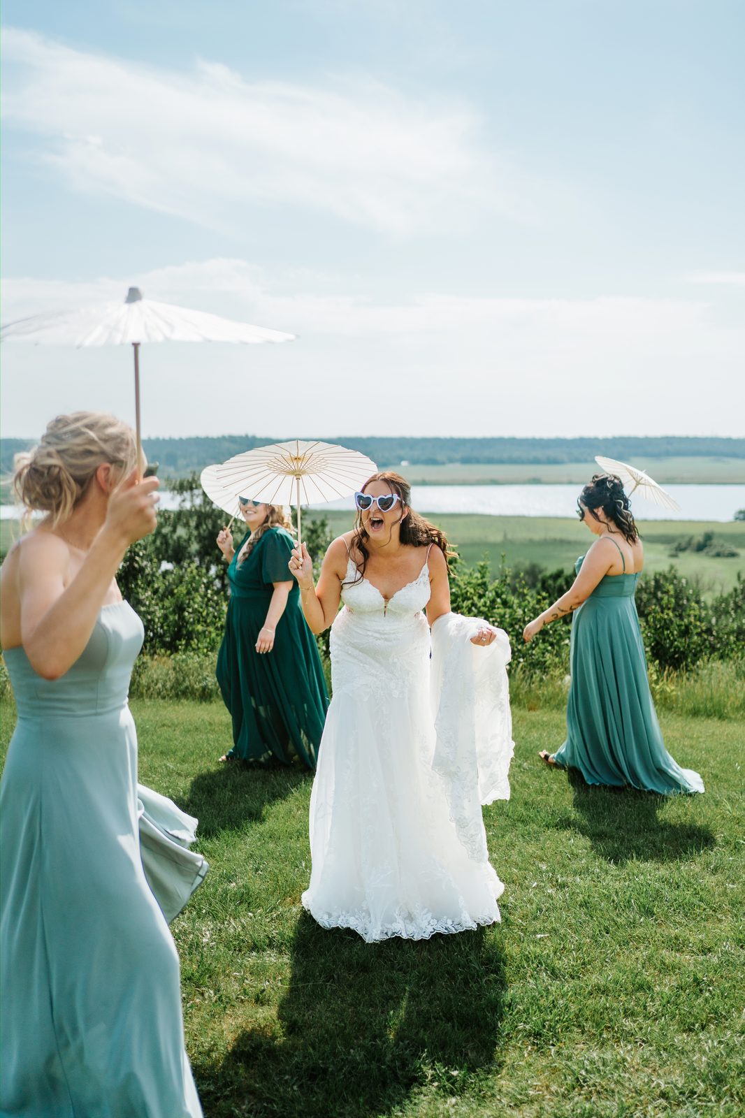 Bridesmaids with parasols and Christina in heart-shaped sunglasses, fun portrait — Pelican Yacht Club wedding, Ninette, Manitoba