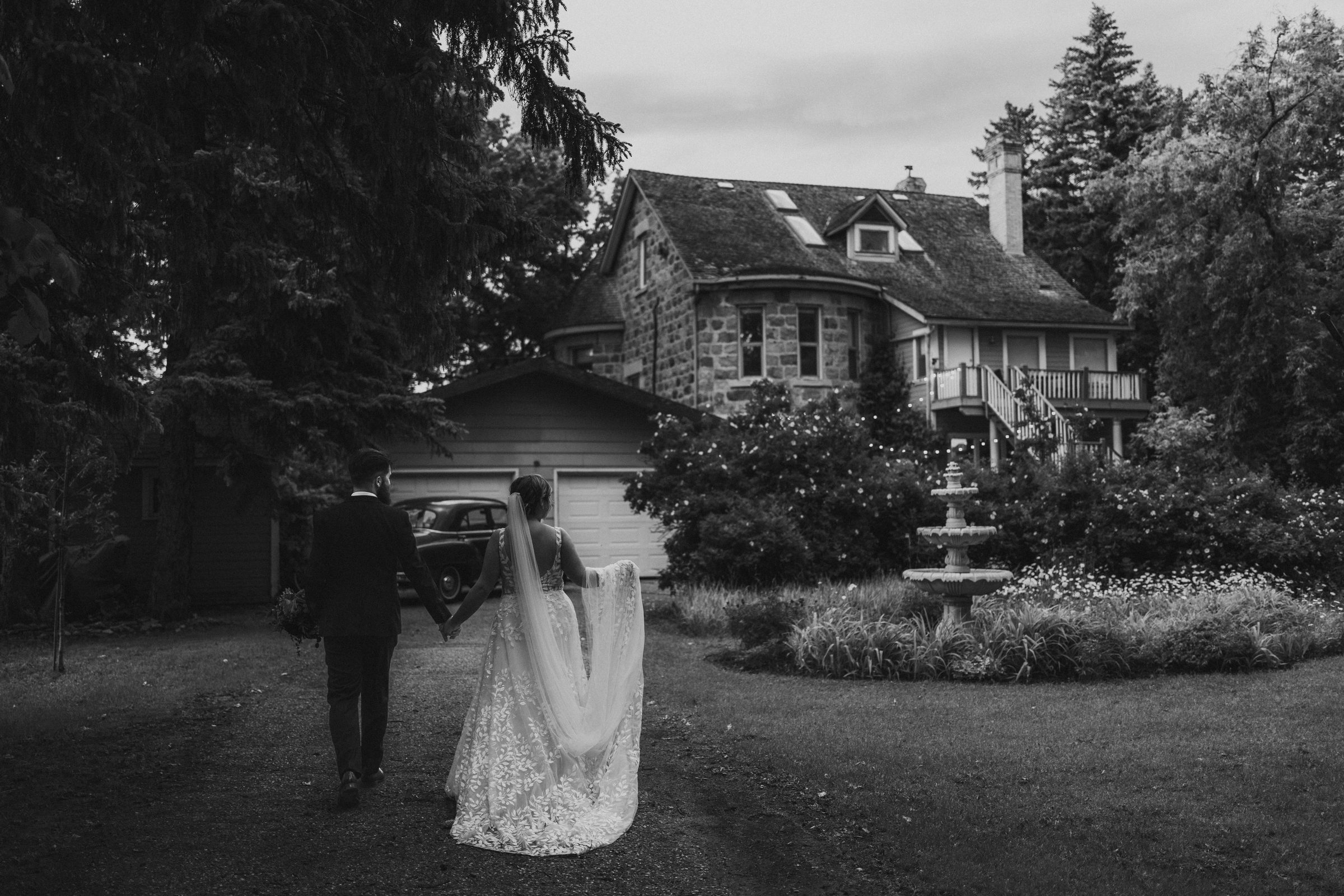 Wedding couple walking to stone estate — editorial Manitoba wedding photographer
