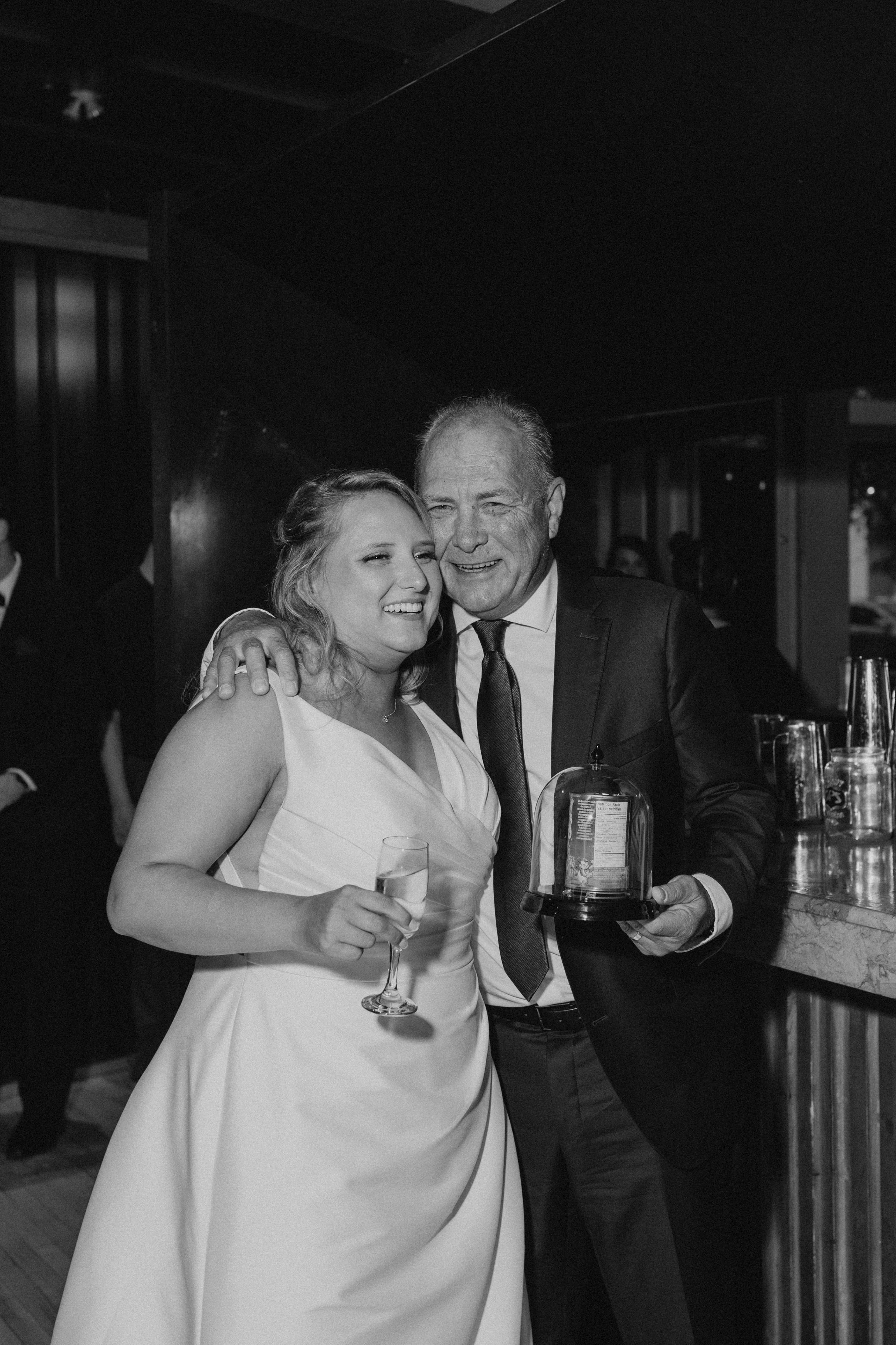 Bailey with her father sharing a moment at the bar at Rudy's reception, both smiling warmly — candid wedding photography by Chris Ngo Winnipeg