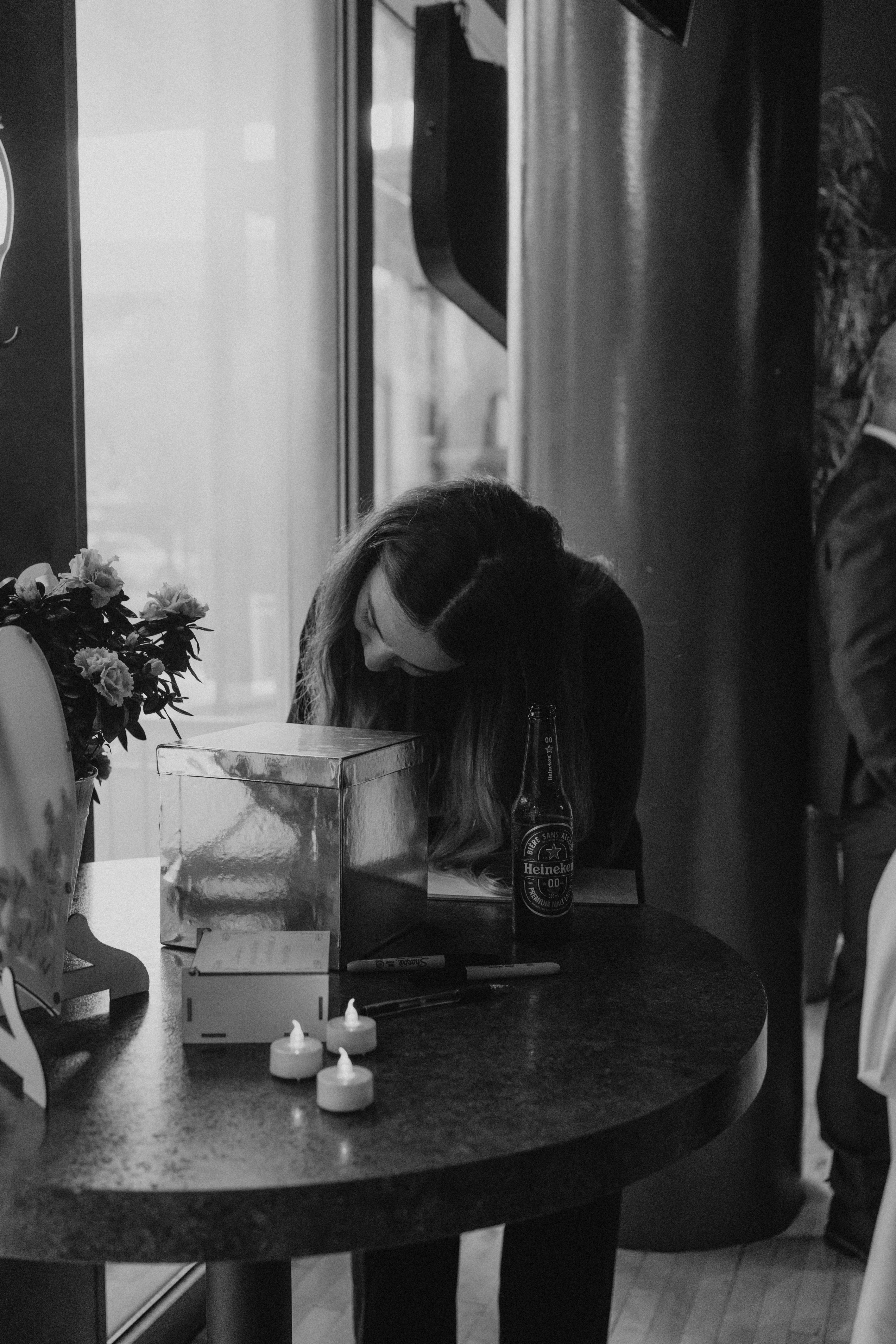 Bridesmaid signing the guestbook at a candlelit table inside Rudy's restaurant before the wedding reception — detail photography by Ngo Photography Winnipeg