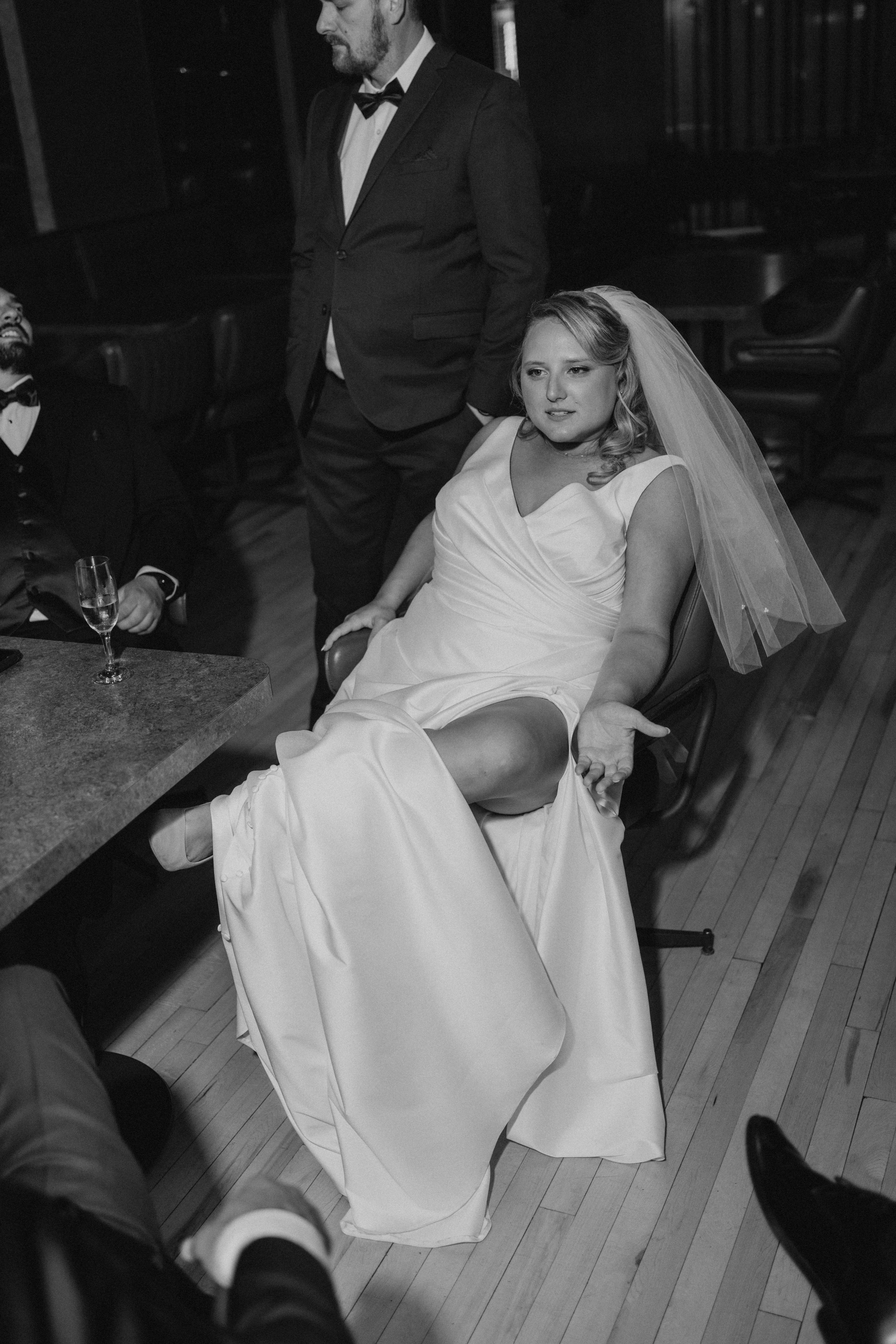 Bailey seated with Dave for the garter removal at their Rudy's wedding reception — candid wedding photography by Ngo Photography Winnipeg