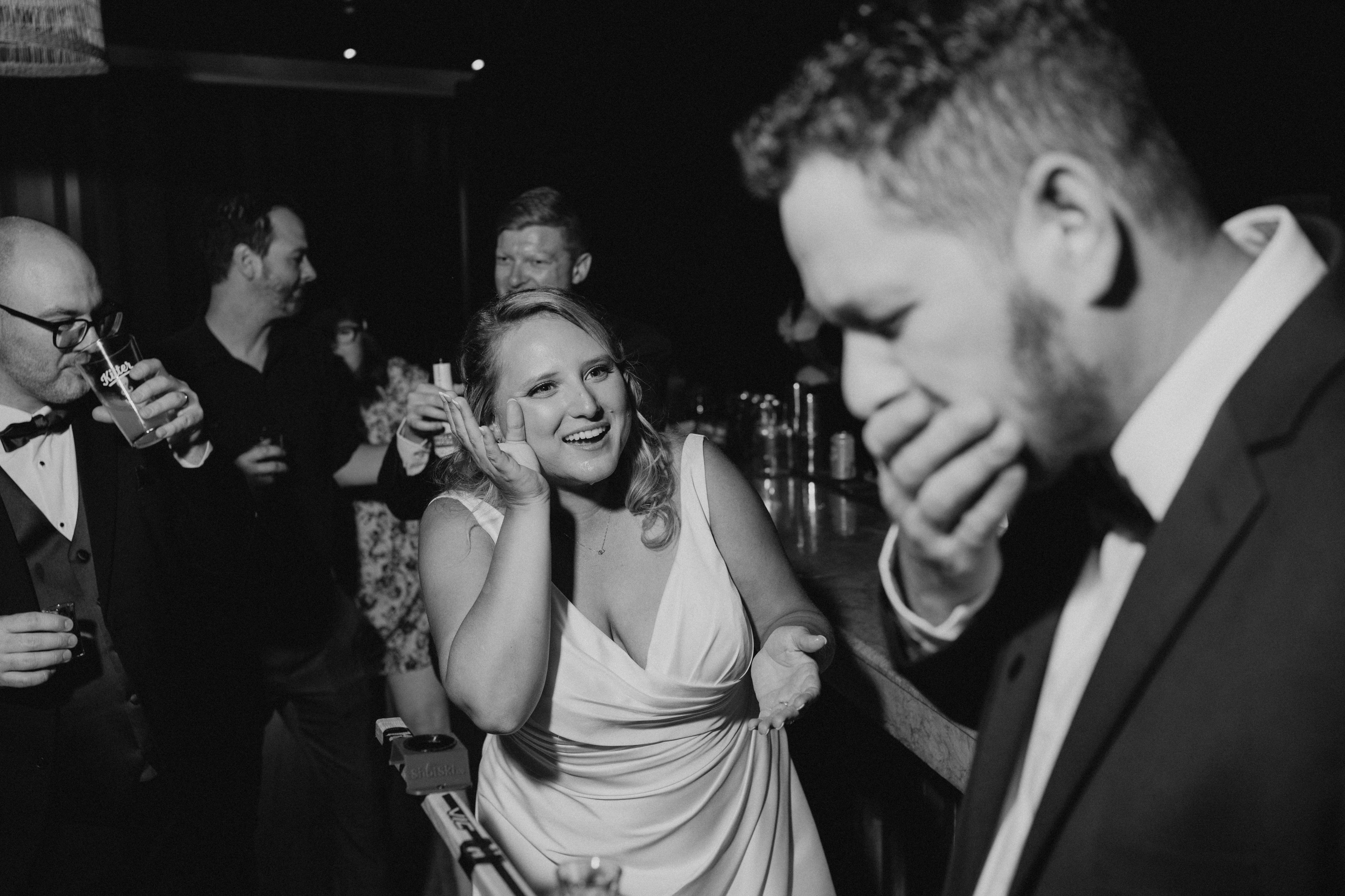 Bailey laughing with Dave at the reception inside Rudy's restaurant — emotional candid wedding photography by Chris Ngo Winnipeg