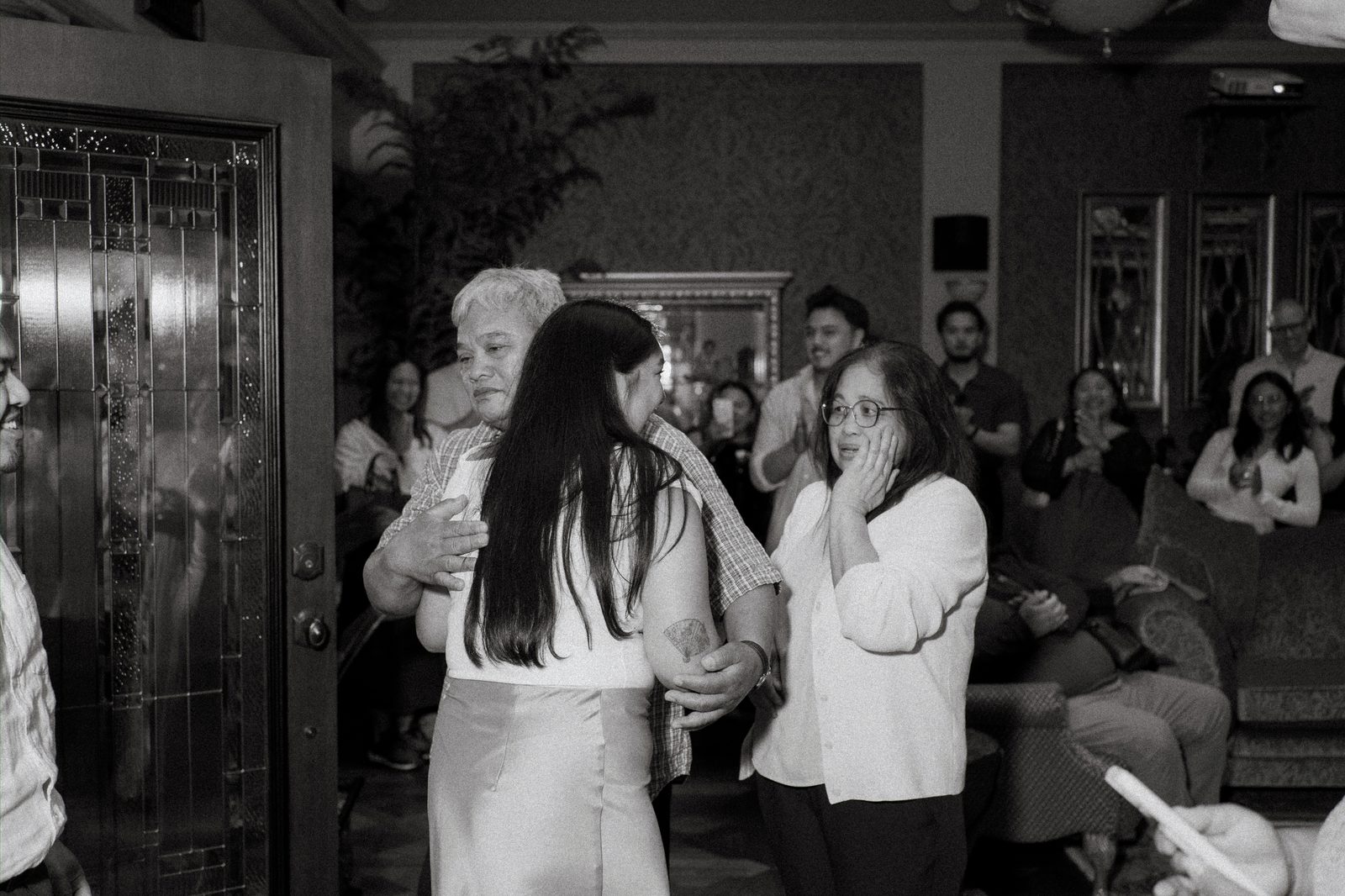 Friends and family rushing in after the surprise proposal — Annie hugging loved ones in the moments after Deril proposed — downtown Winnipeg surprise proposal photography by Chris Ngo Ngo Photography