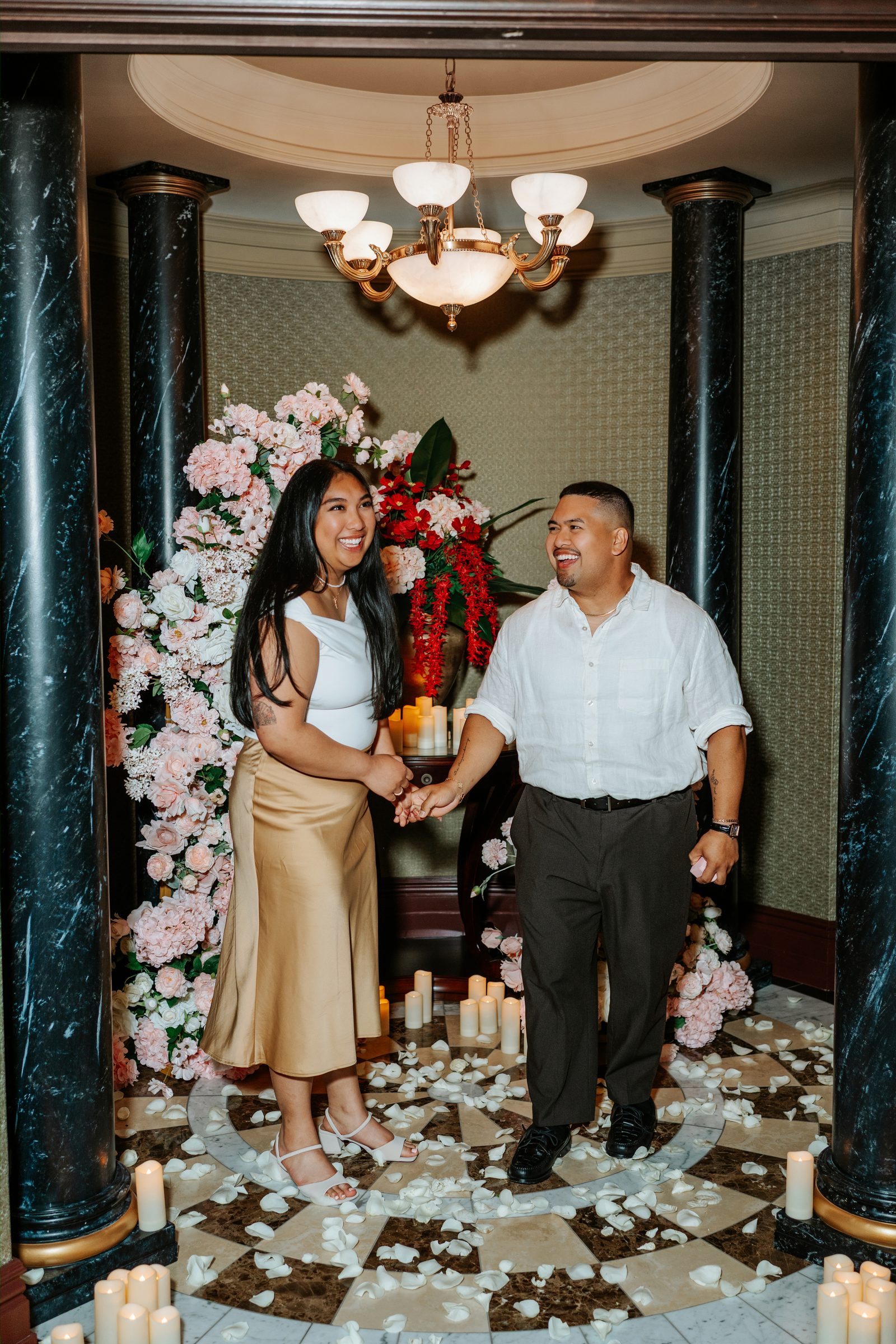 Deril and Annie intimate portrait at the proposal arch — soft candlelight, marble, rose petals — downtown Winnipeg proposal photographer Chris Ngo
