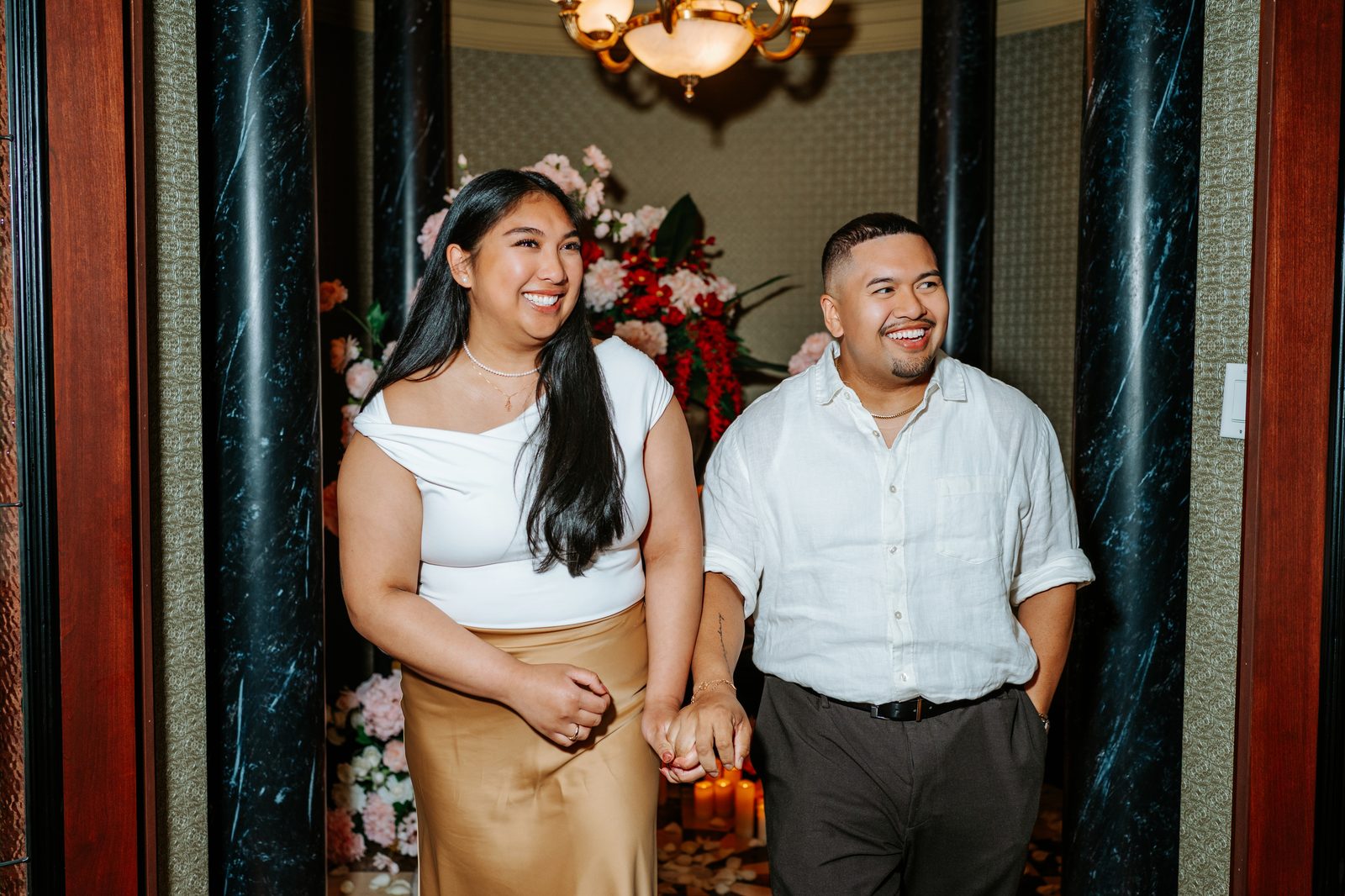 Annie and Deril close portrait just after the surprise proposal — candlelit arch behind them — Ngo Photography downtown Winnipeg