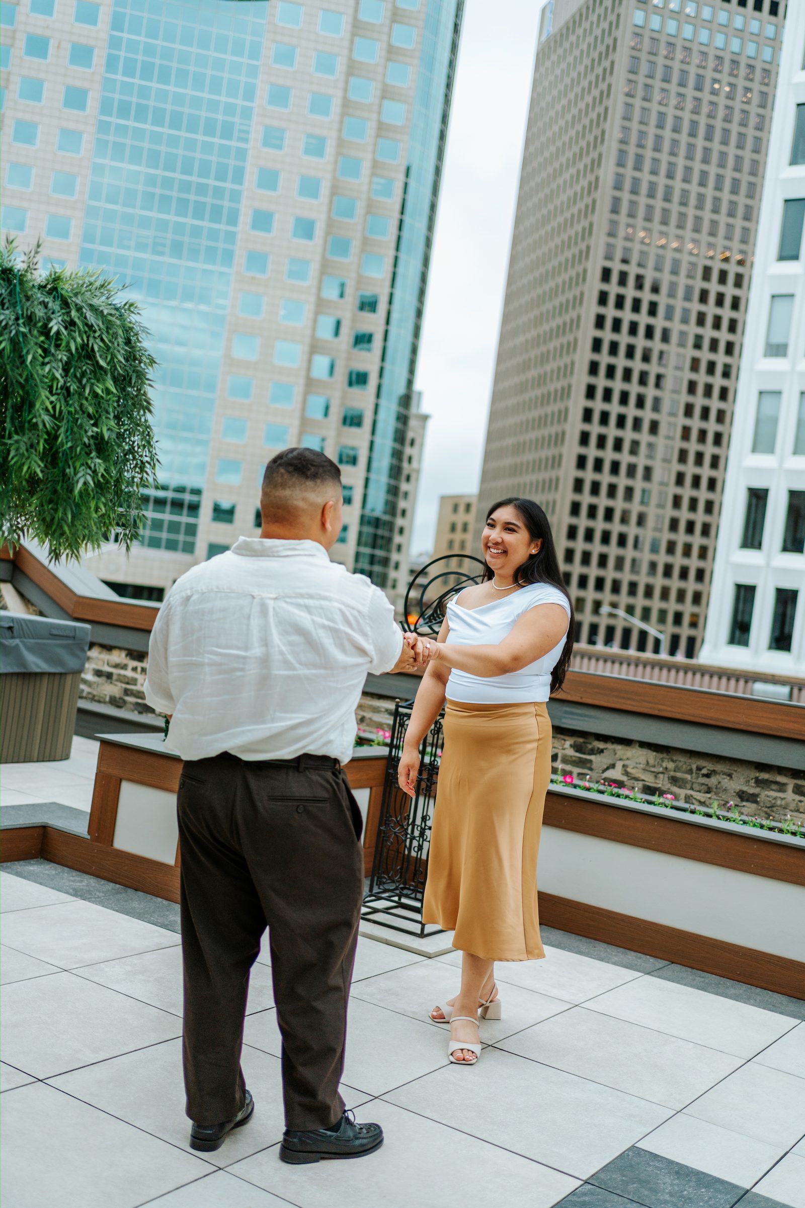 Deril and Annie walking on the rooftop terrace above downtown Winnipeg — surprise proposal photographer Chris Ngo