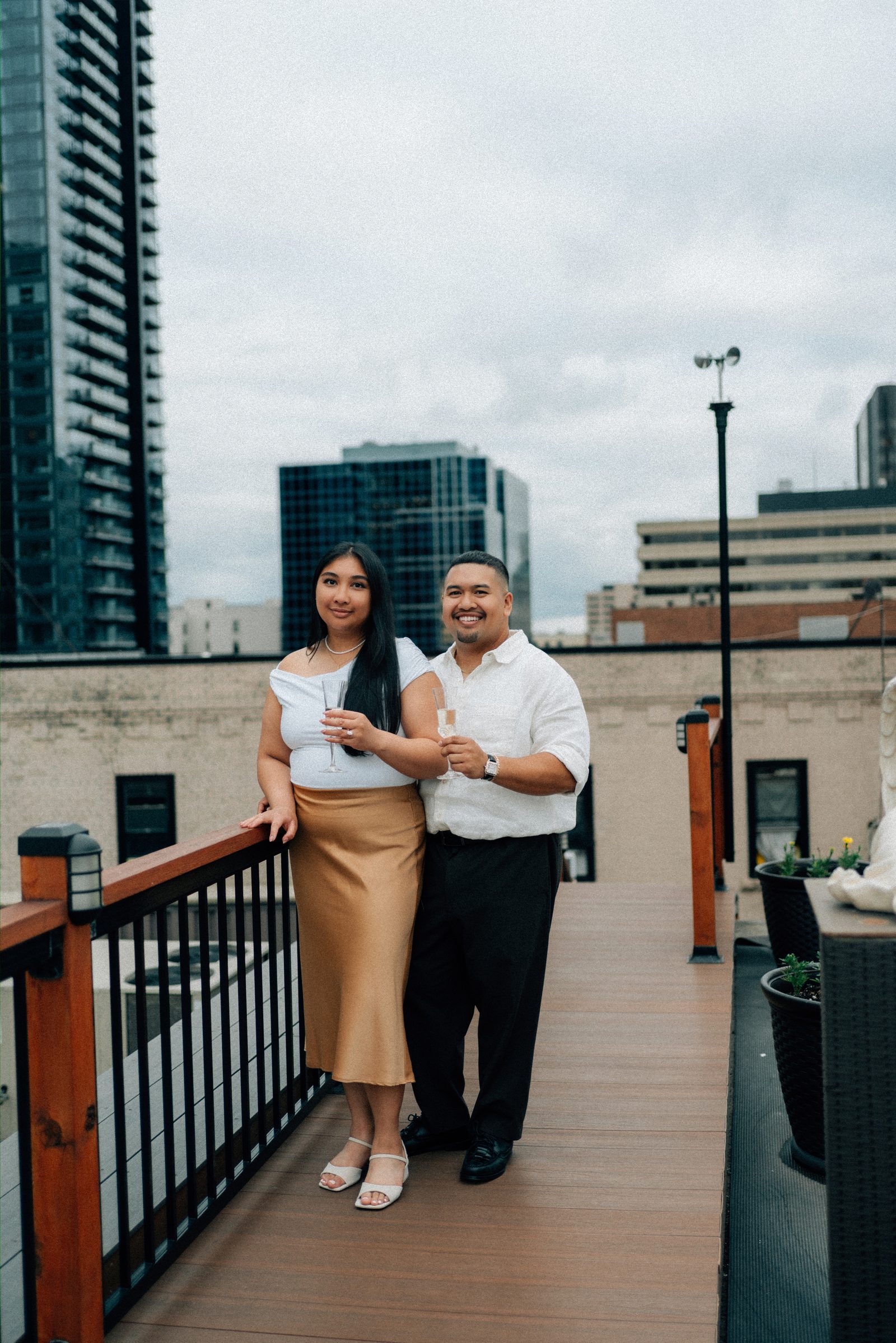 Deril and Annie close portrait on the staircase with wrought iron railing and candlelight — downtown Winnipeg proposal photography by Ngo Photography