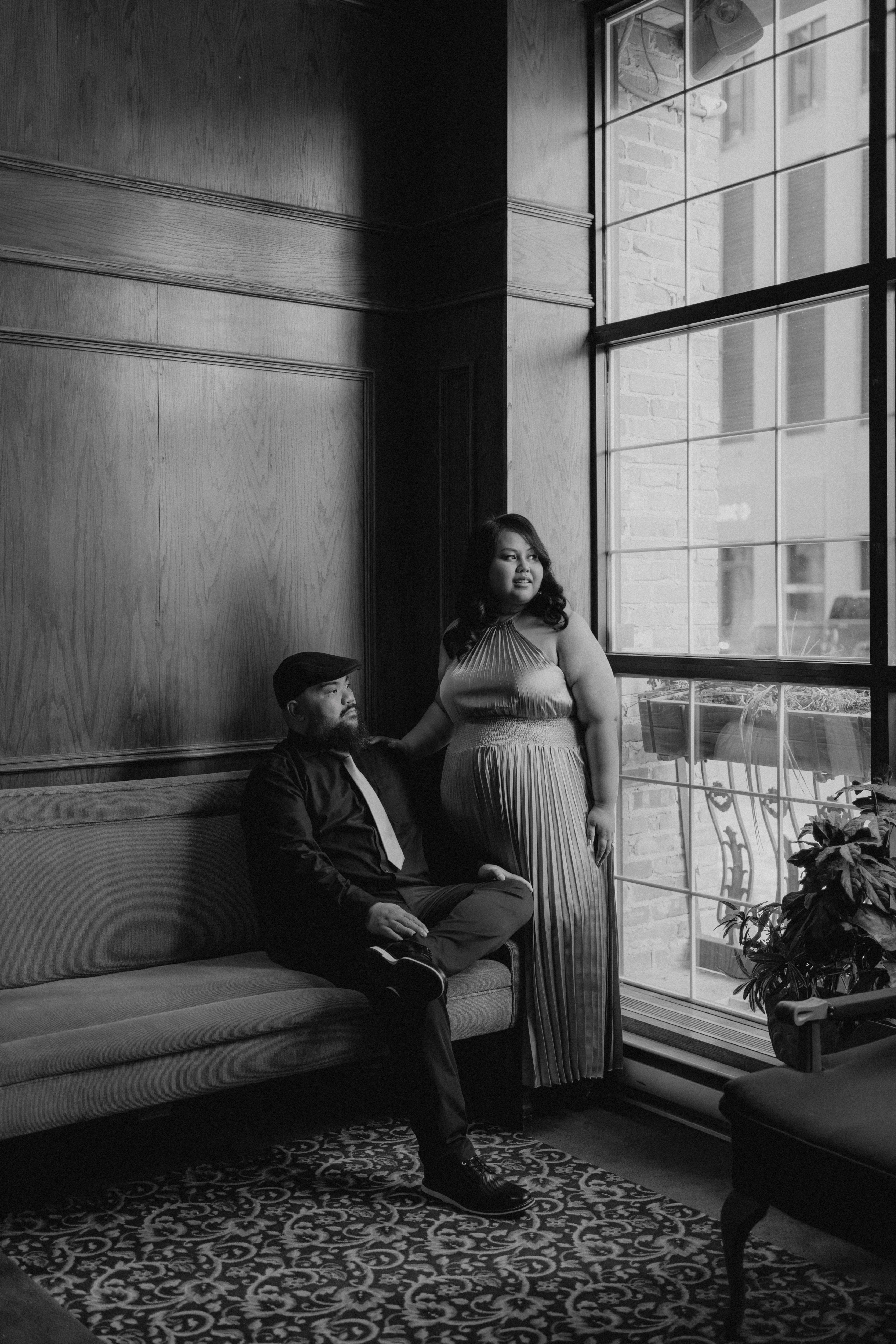 Dre and Judy in a quiet moment in the Fort Garry Hotel lobby — black and white engagement photography by Ngo Photography Winnipeg