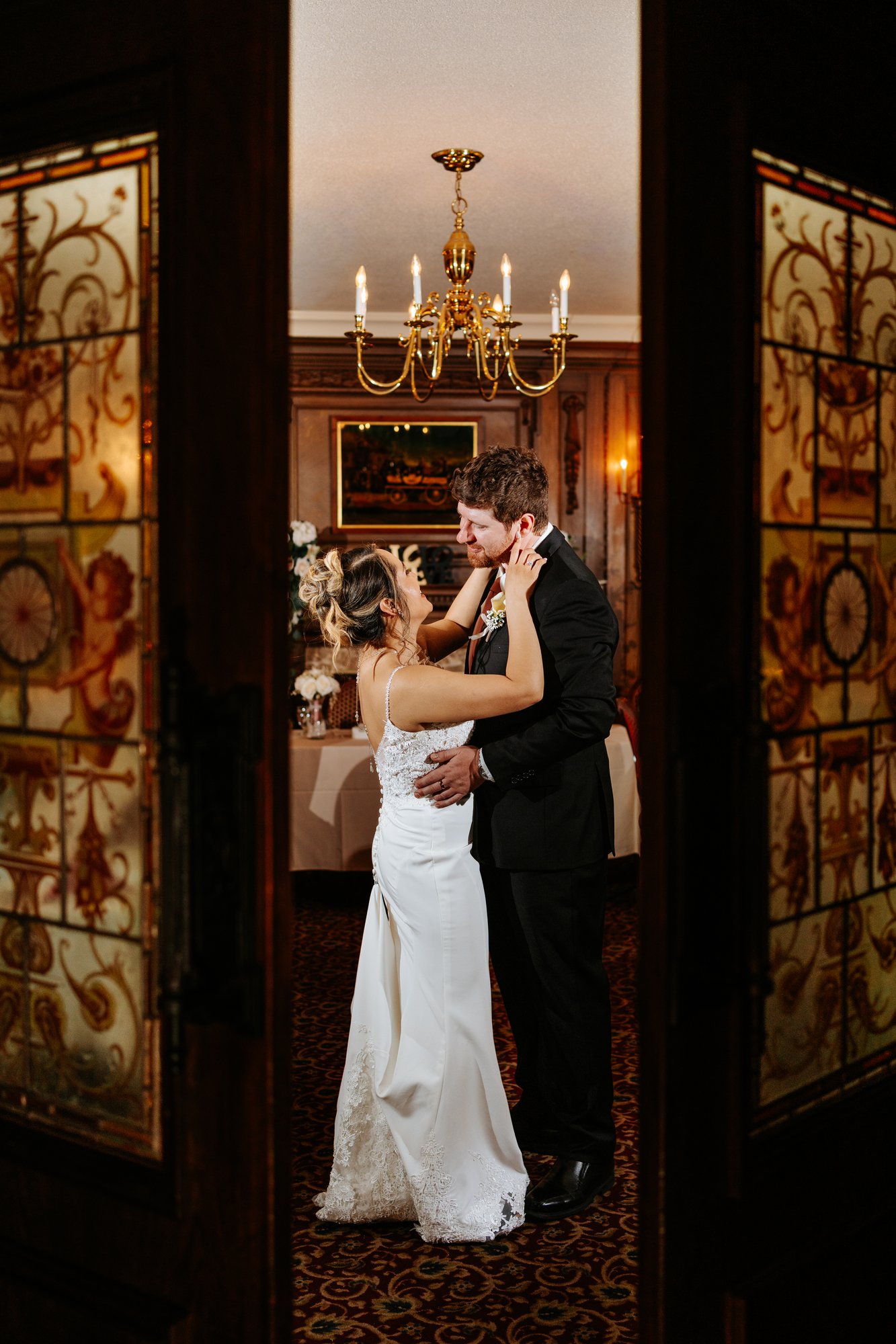Eden and Justin first dance through ornate stained glass doors at Bailey's Restaurant wedding Winnipeg — Ngo Photography