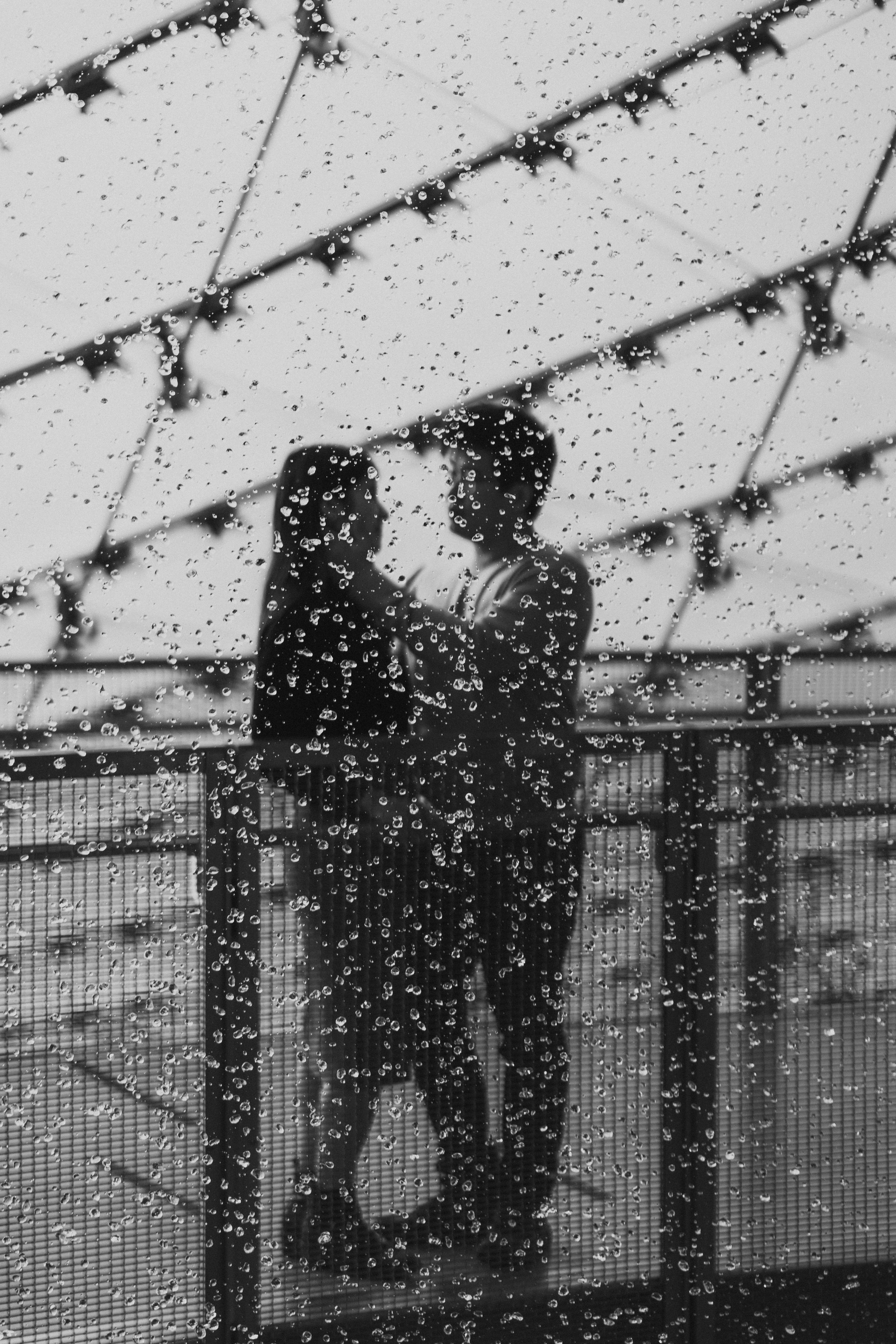 Winnipeg wedding couple through rainy window — editorial wedding photography by Ngo Photography