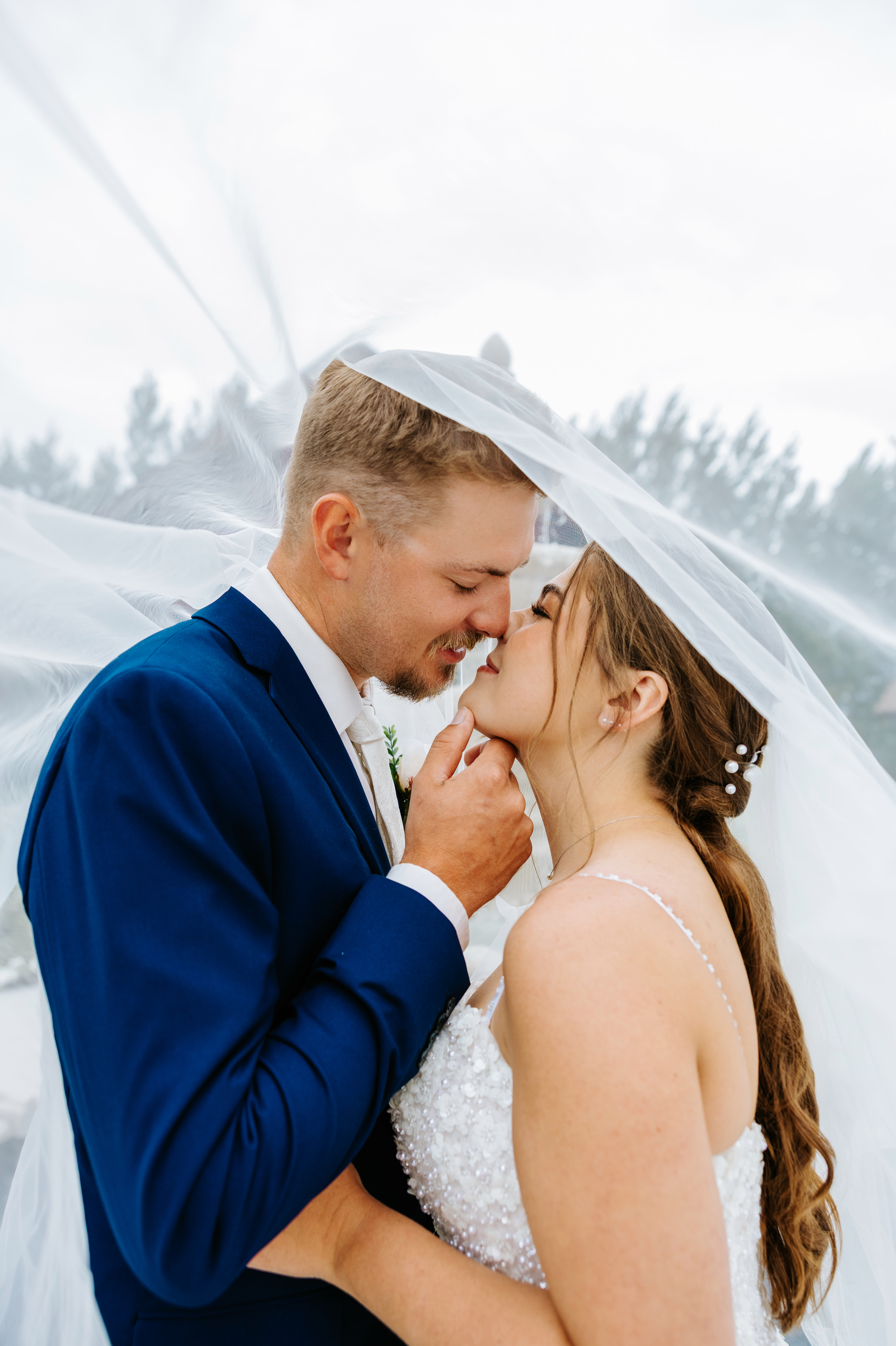 Jayden and Erin pulled close under her flowing veil — intimate veil portrait at Buttercup Café Manitoba by Chris Ngo Ngo Photography