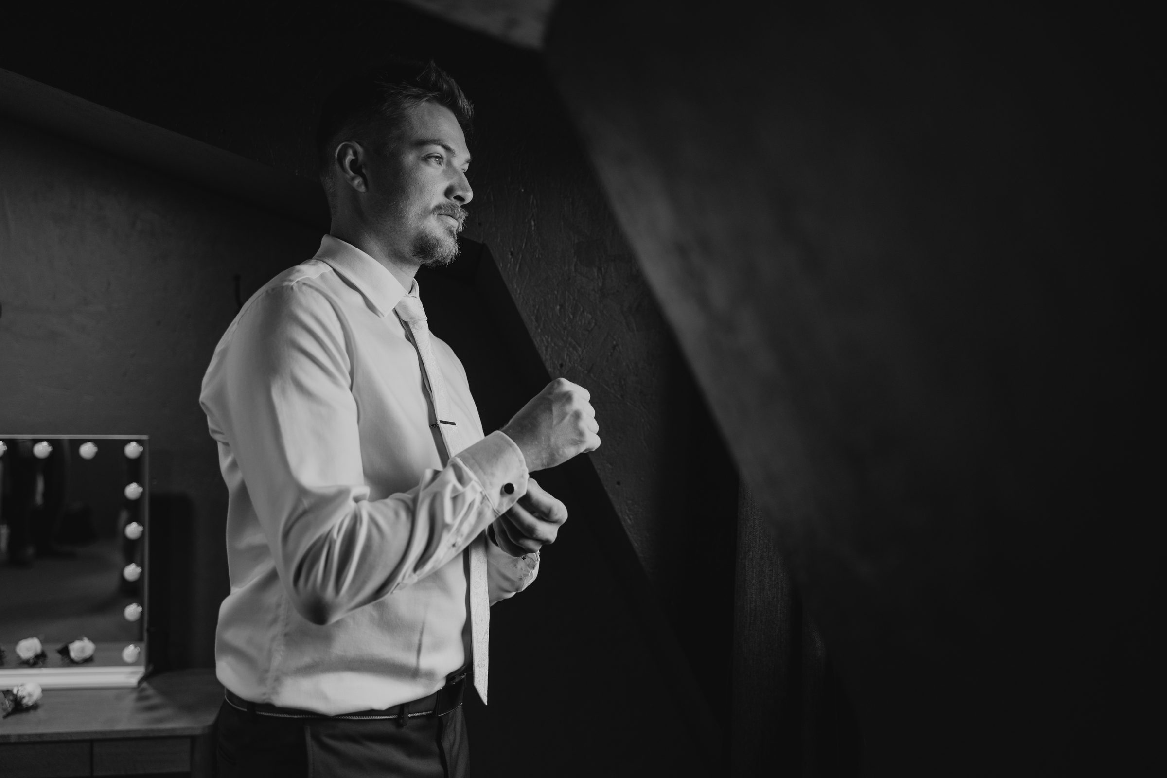 Jayden doing up his cufflinks while getting ready for his wedding at Buttercup Café Manitoba — Ngo Photography