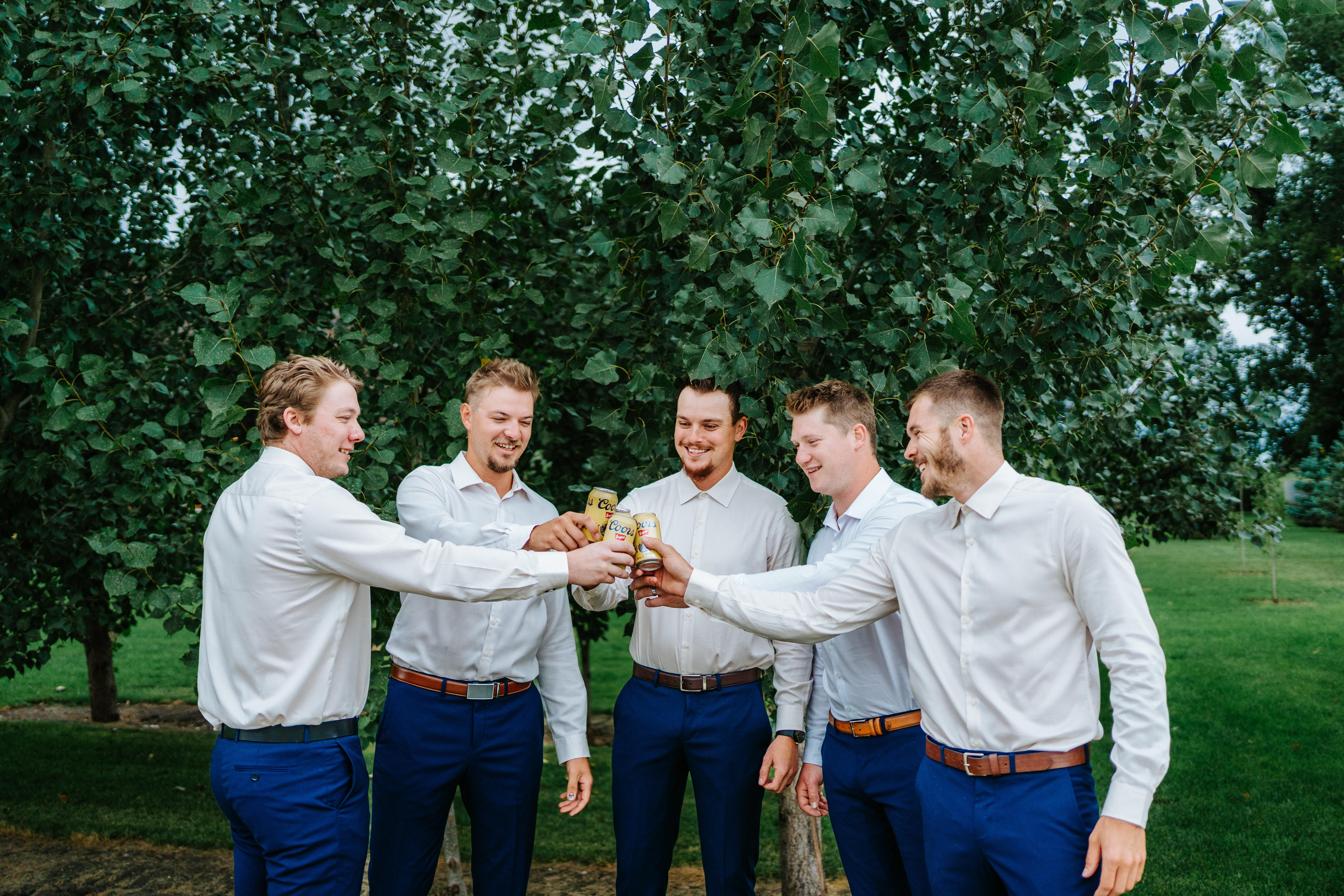 Jayden and groomsmen raising drinks under the trees at Buttercup Café before the wedding — candid getting ready photography by Chris Ngo