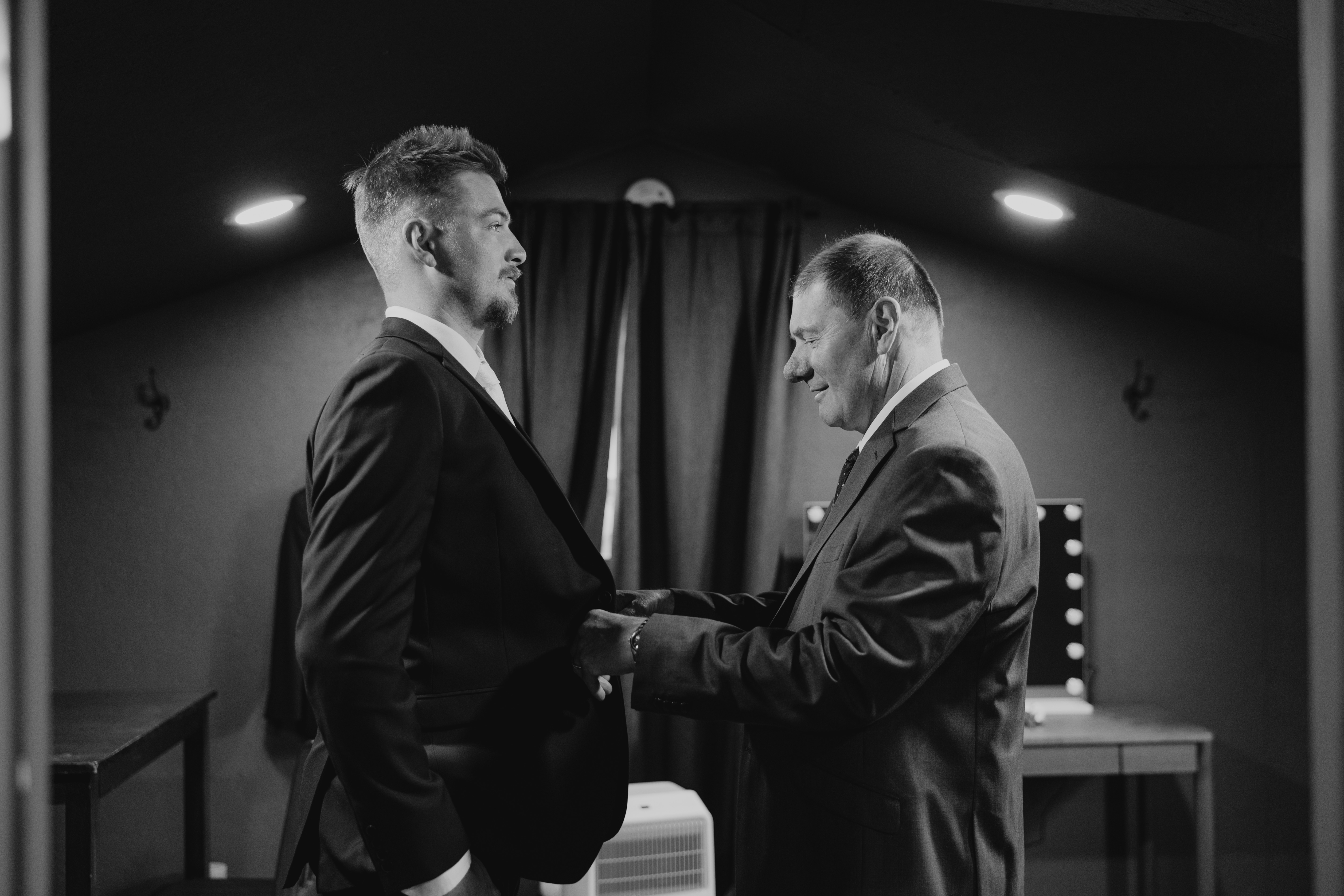 Jayden's father helping him into his suit jacket in the groom's suite at Buttercup Café — emotional getting ready moment, Ngo Photography Manitoba