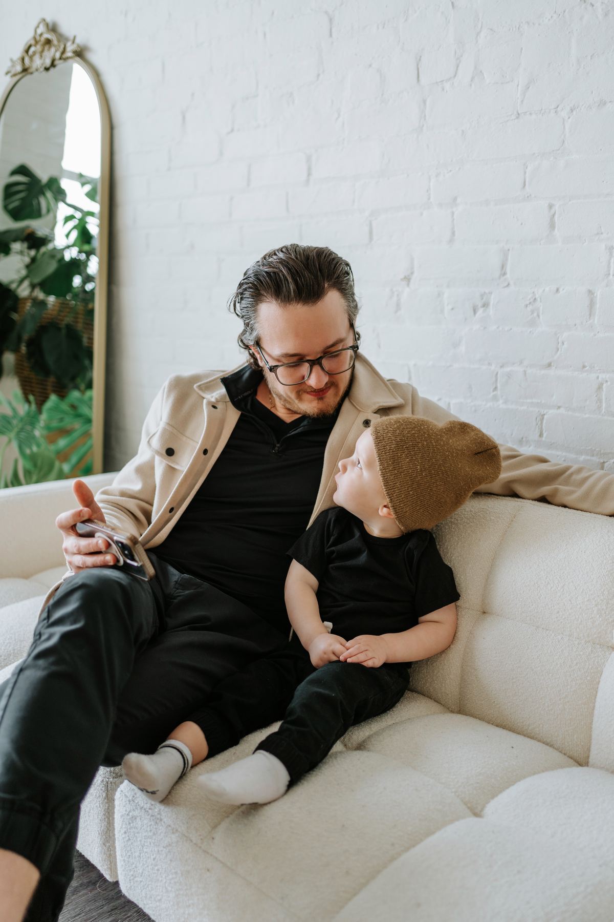 Father and toddler son sharing a warm moment on a studio couch — Winnipeg family portrait session by Ngo Photography