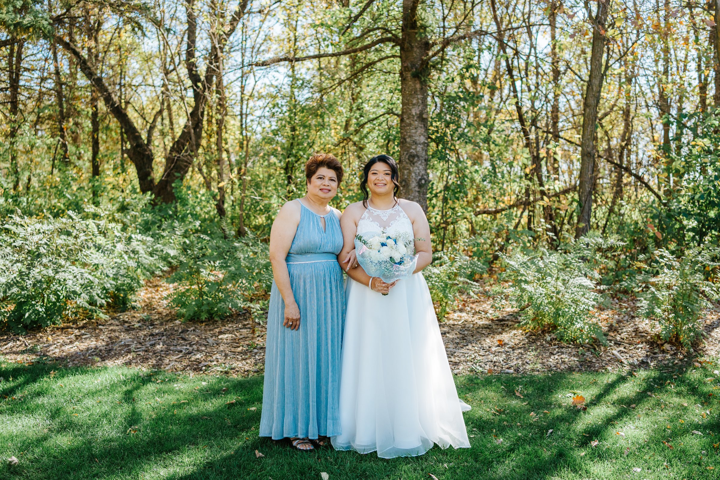 Two brides embrace during their first look at Bel Acres Golf and Country Club — photography by Chris Ngo