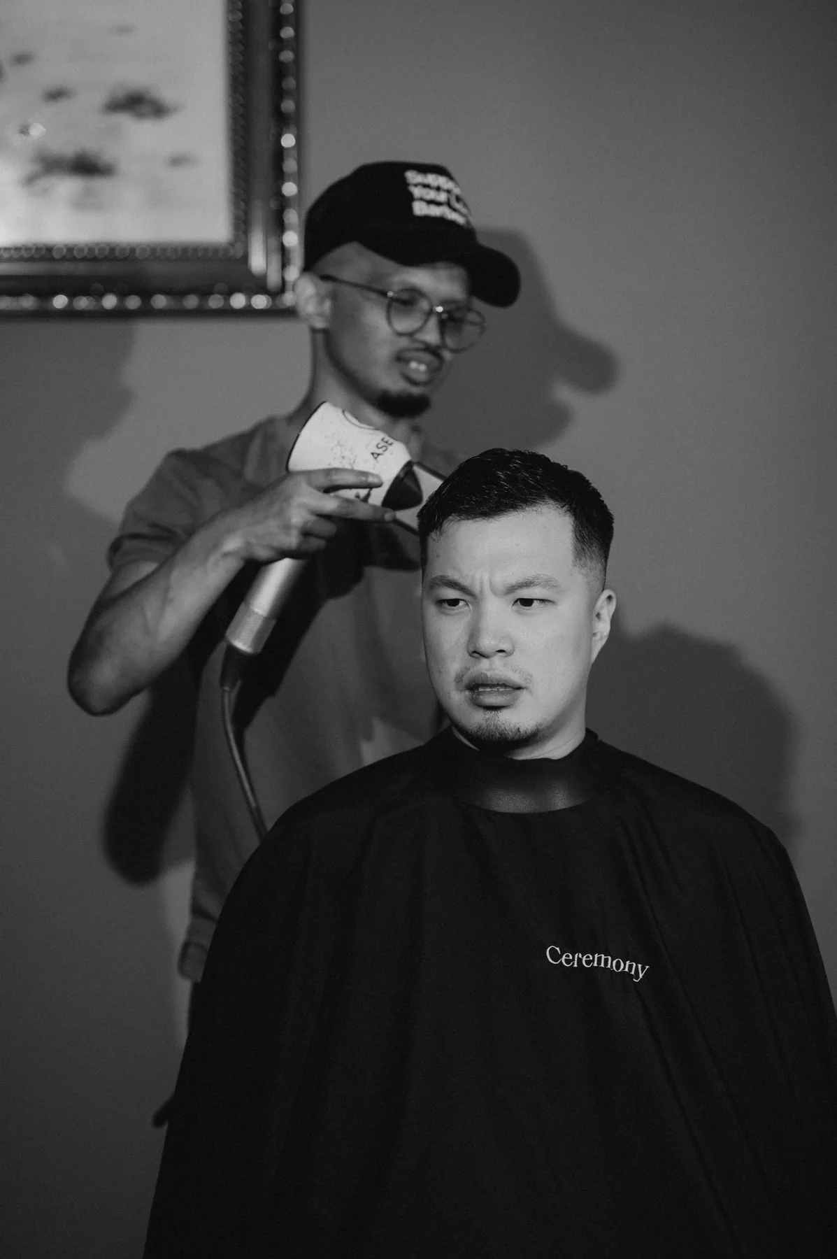 Groom Homan in the barber chair getting a wedding morning haircut, black and white — Bridges Golf Course wedding, Winnipeg