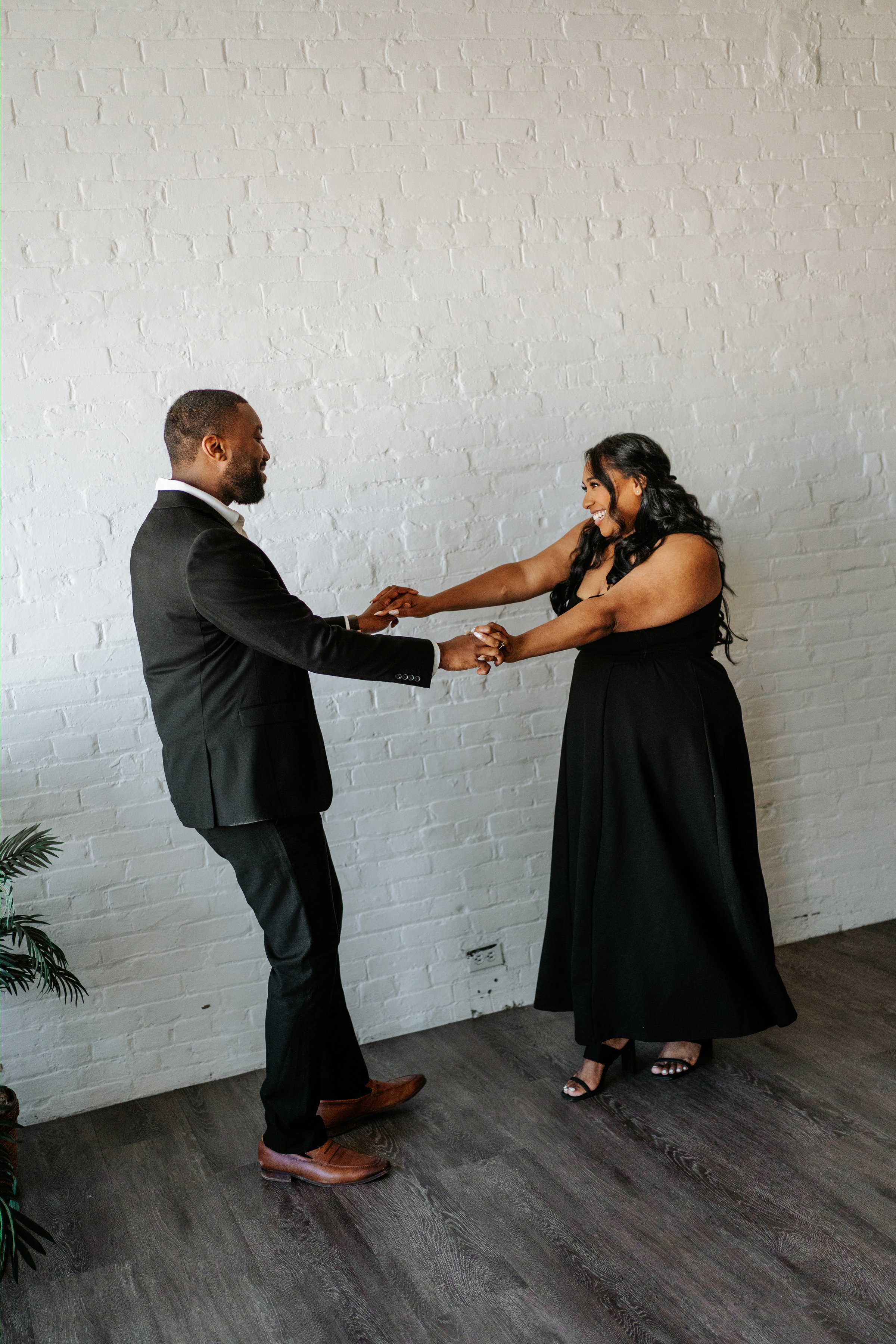 Jaida and Jordan on a downtown Winnipeg street with the city skyline behind them — engagement photography by Chris Ngo Ngo Photography