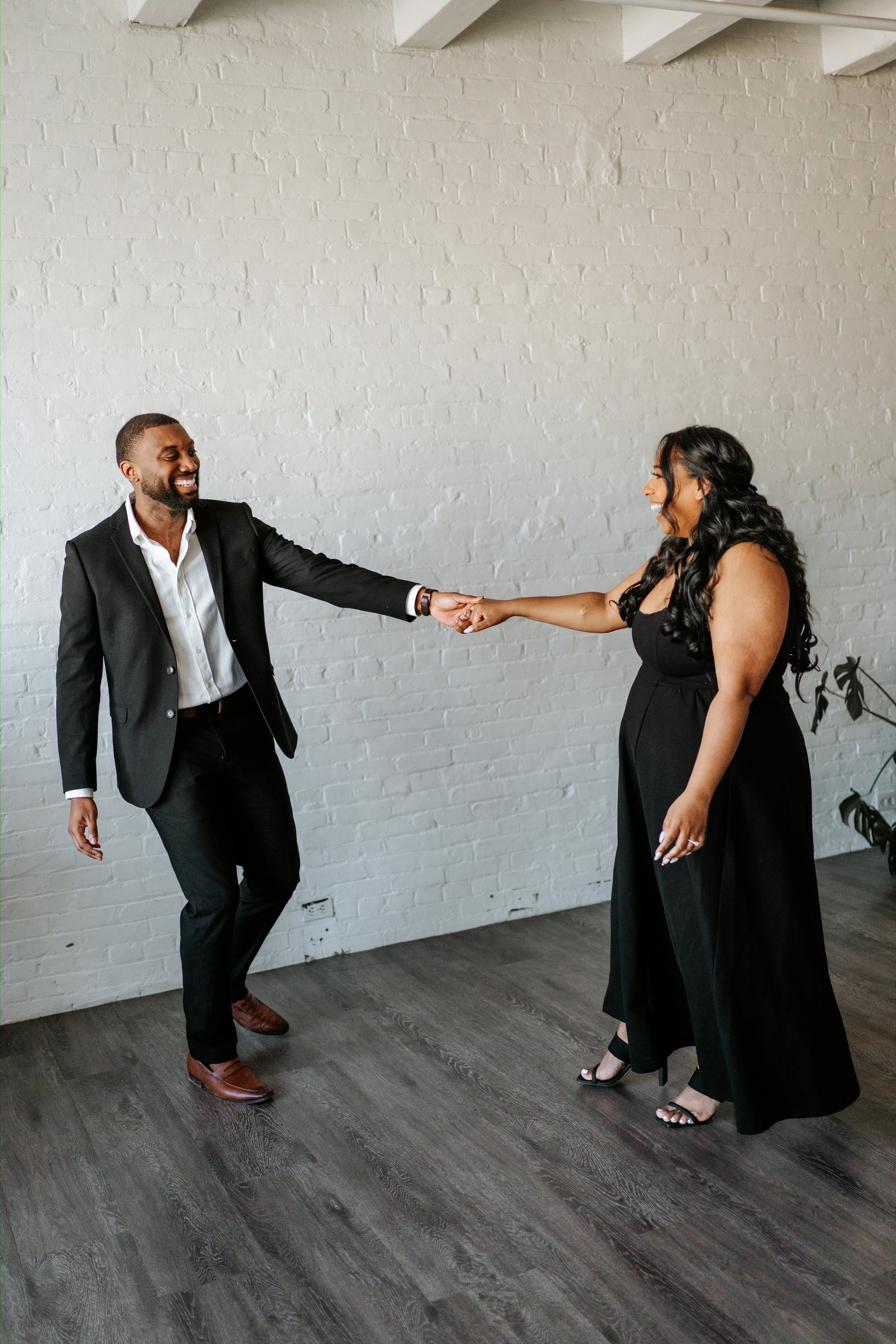 Jaida laughing with Jordan on a downtown Winnipeg street — engagement session photography by Chris Ngo