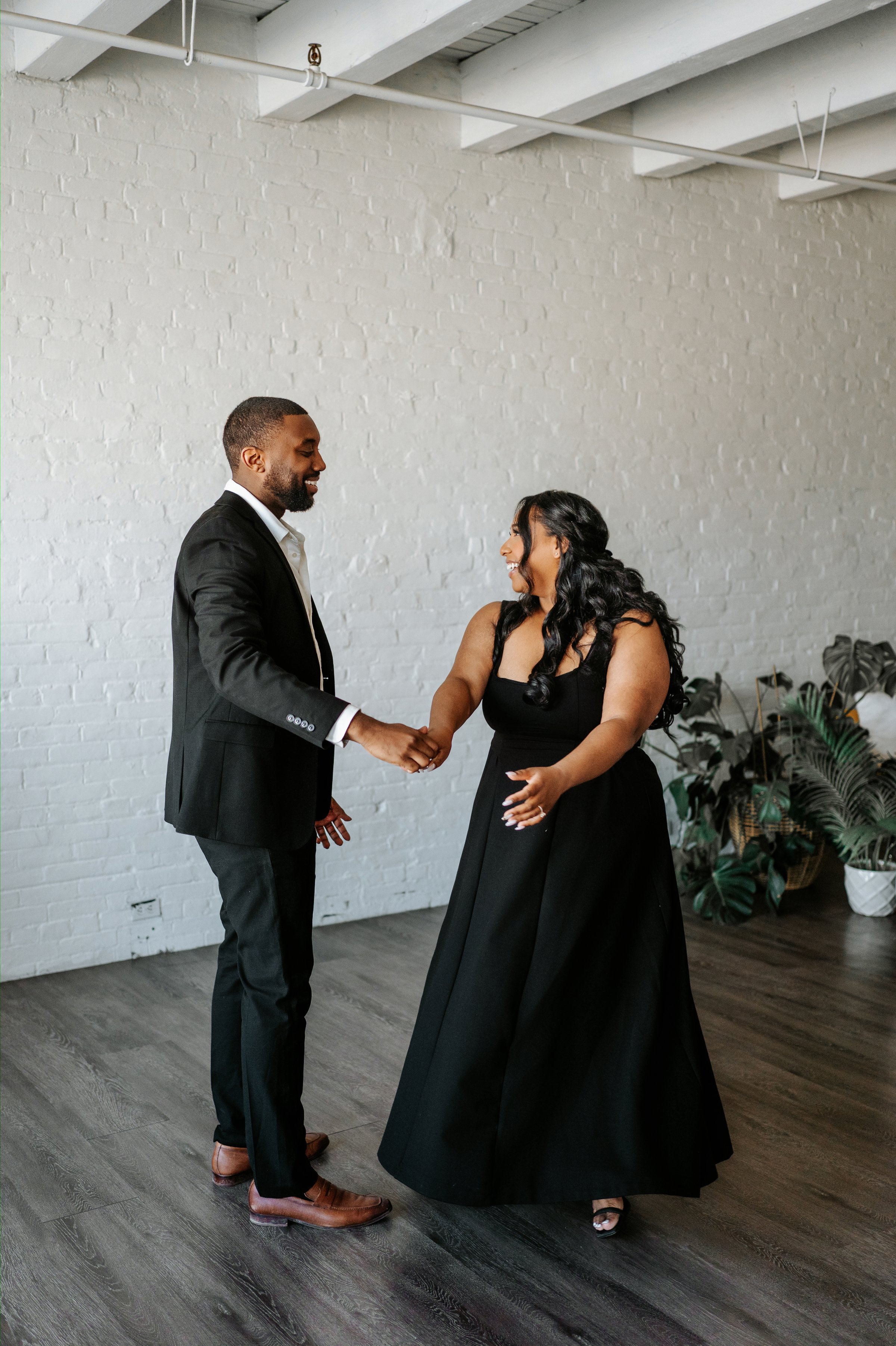 Jaida and Jordan embracing on a downtown Winnipeg street — engagement photography by Ngo Photography