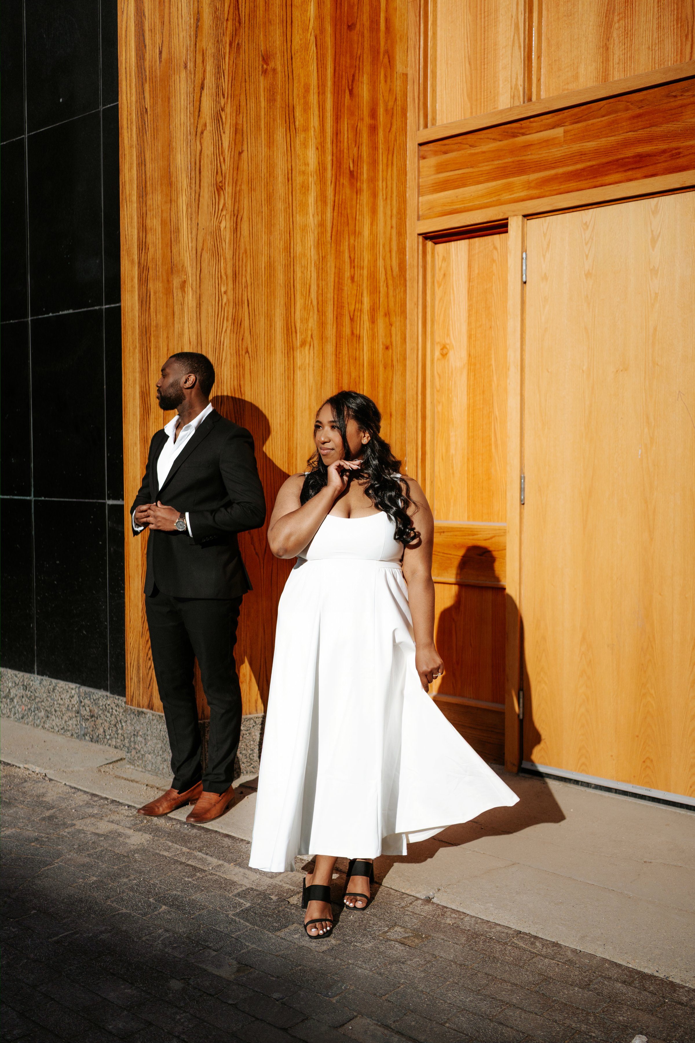 Jordan holding Jaida at golden hour on a Winnipeg parkade rooftop — engagement photography by Ngo Photography