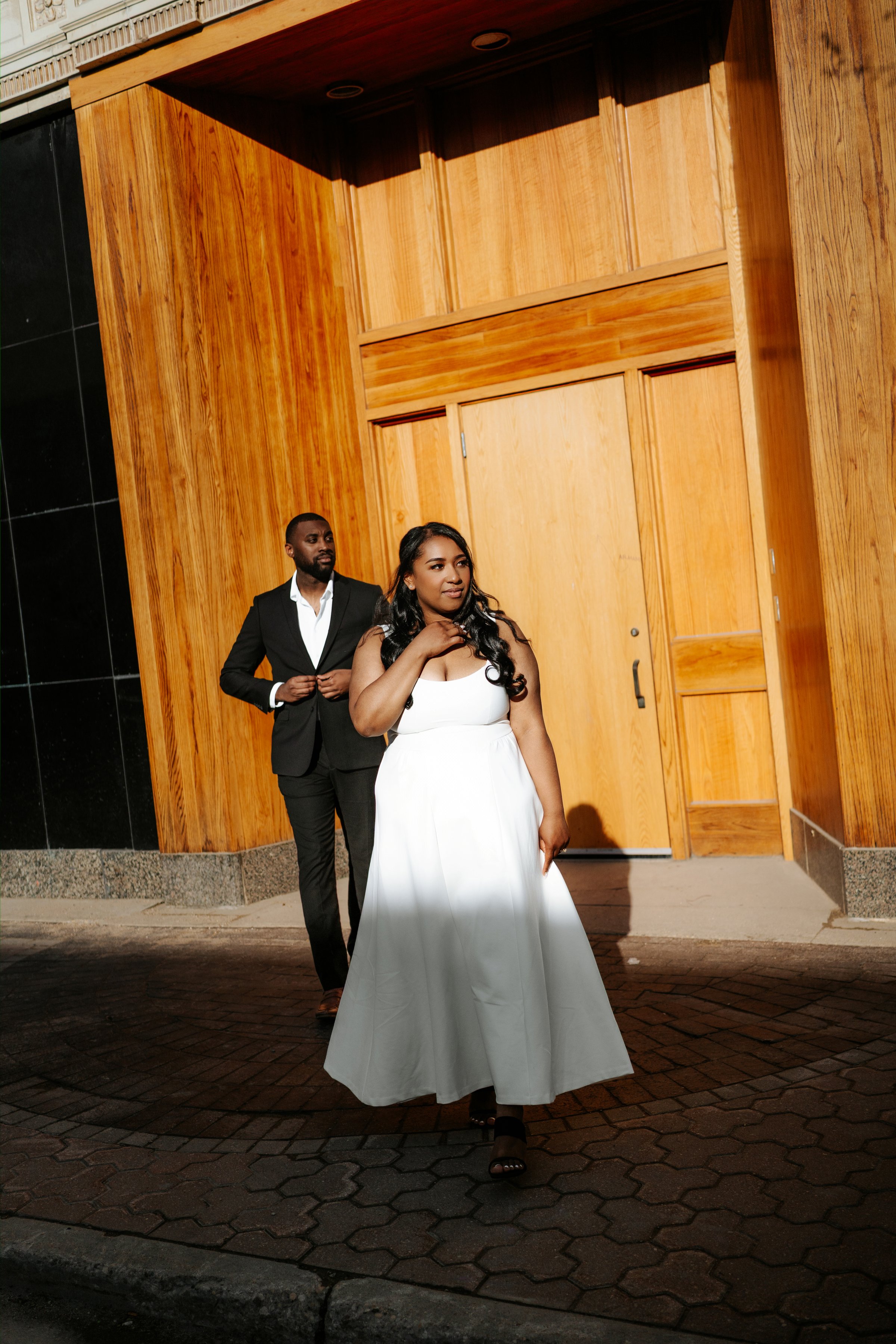 Jaida and Jordan walking on a downtown Winnipeg parkade at sunset — engagement photography by Chris Ngo