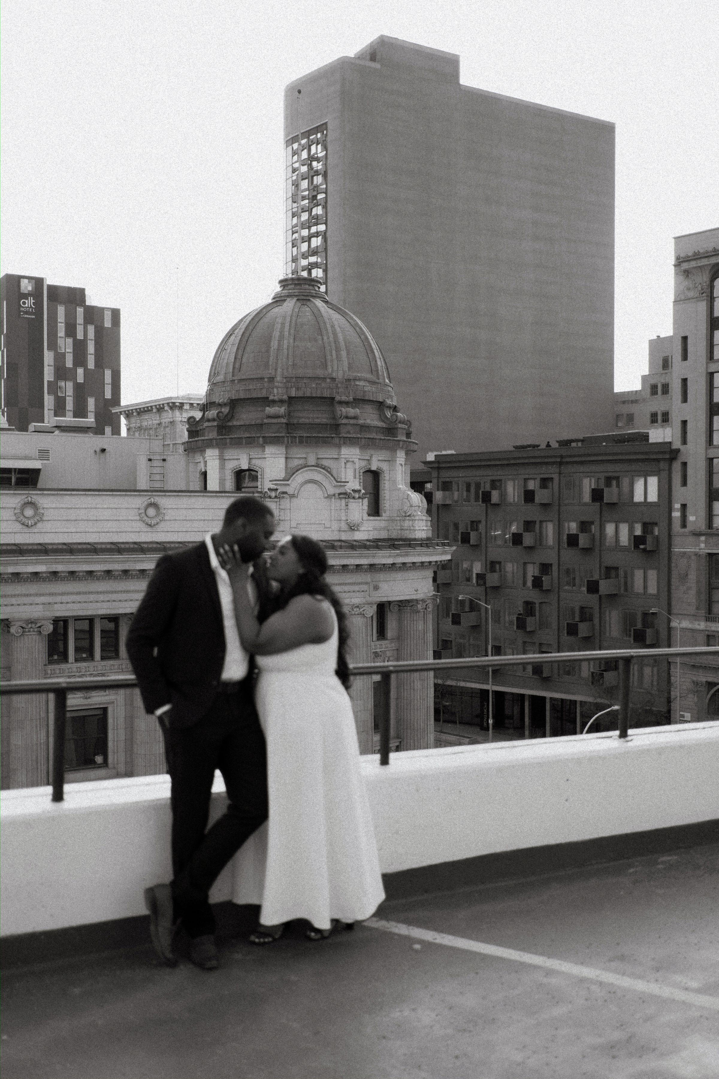 Jaida and Jordan silhouette at golden hour on a downtown Winnipeg parkade — engagement photography by Chris Ngo