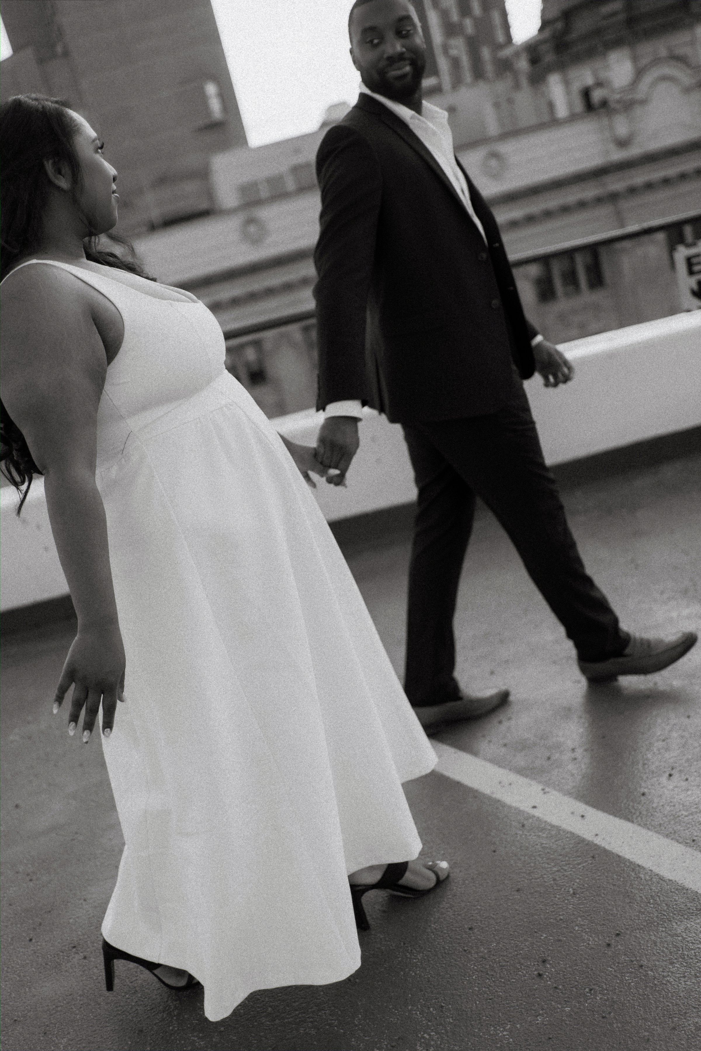 Jordan holding Jaida at golden hour on a downtown Winnipeg parkade rooftop — engagement photography by Chris Ngo