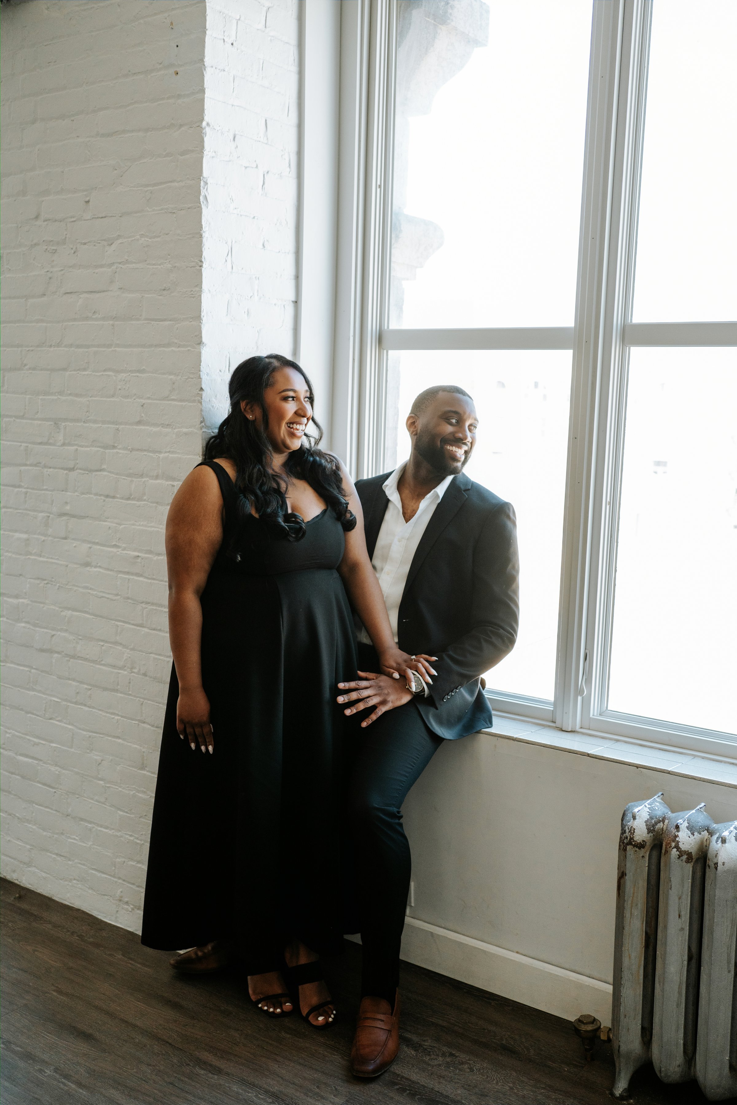 Jaida and Jordan laughing together in downtown Winnipeg's Exchange District — engagement photography by Chris Ngo