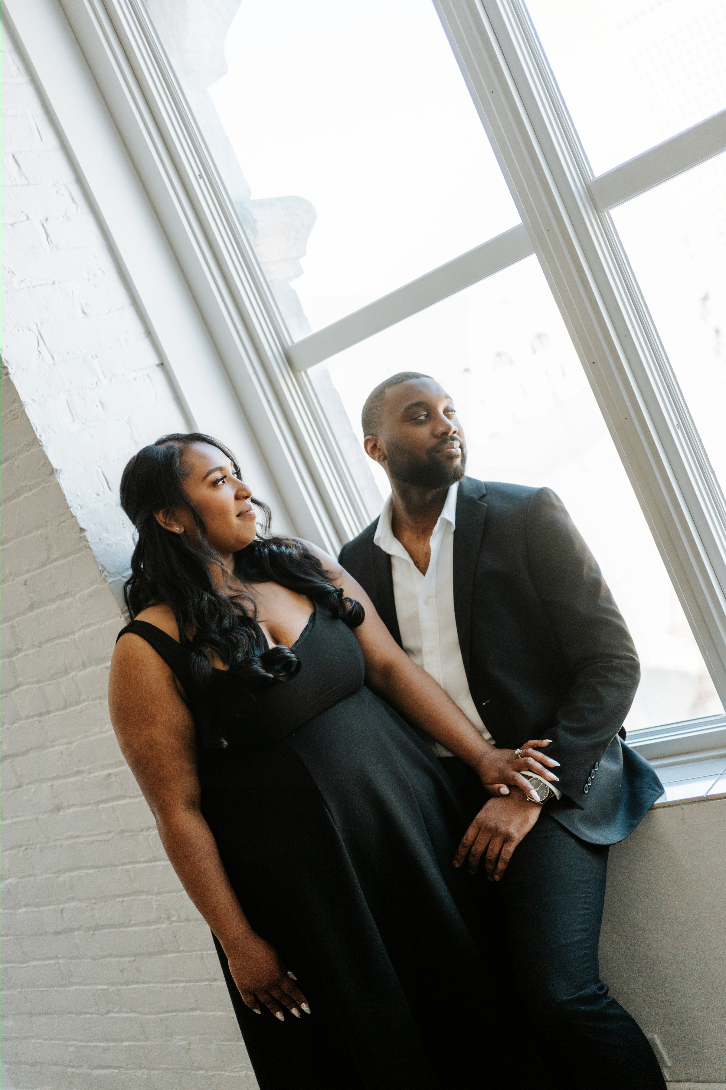 Jaida and Jordan in an Exchange District alley with heritage architecture behind them — downtown engagement photography by Ngo Photography