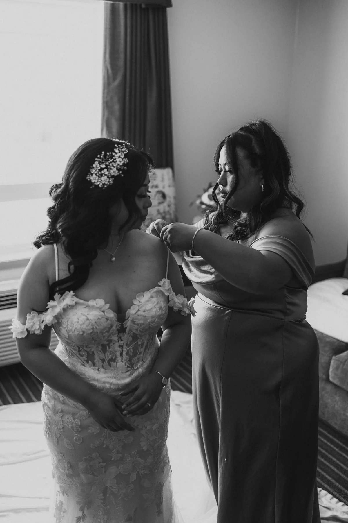 Bridesmaid lacing up Jay's wedding gown in black and white — Hawthorne Estates wedding, Manitoba