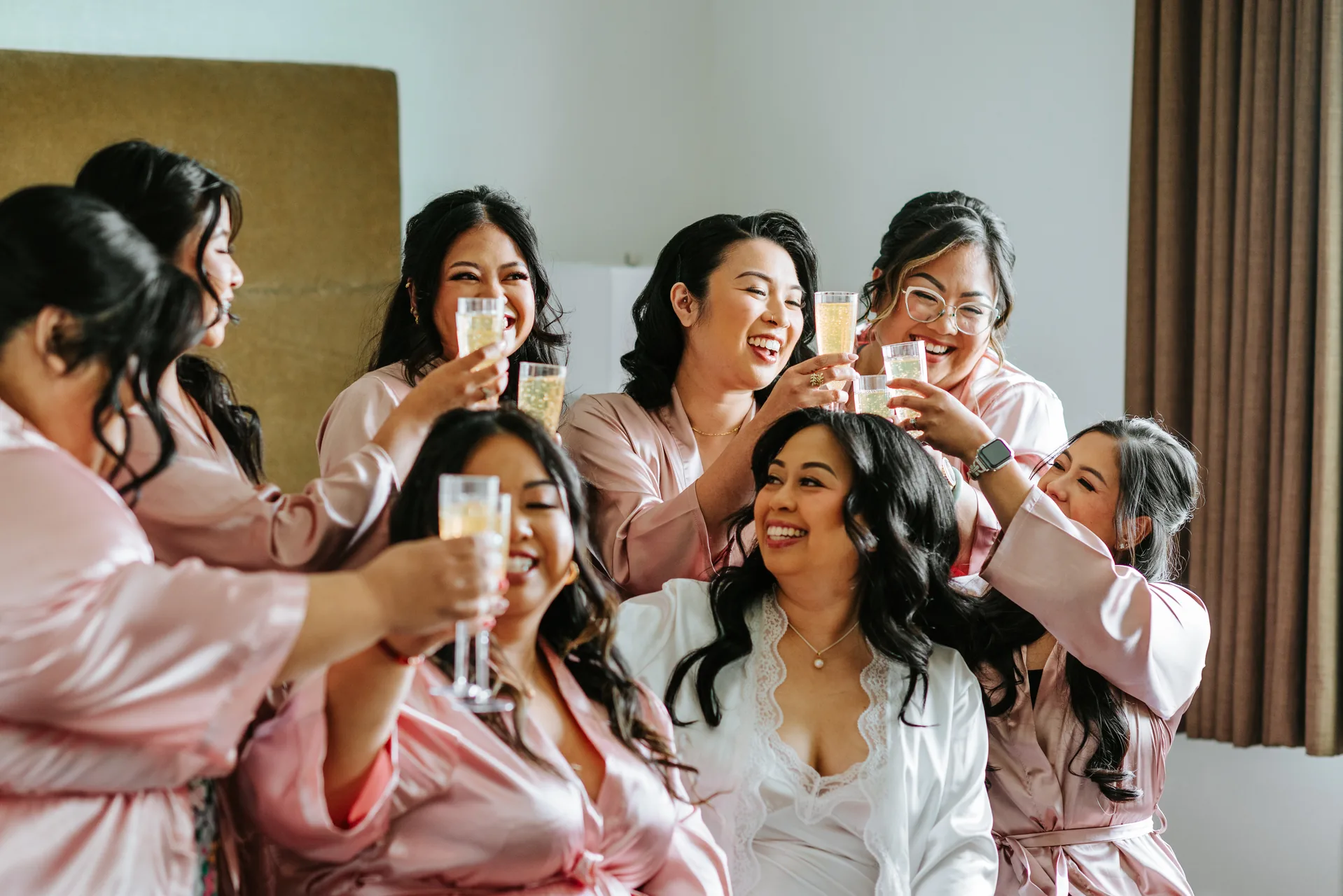 Bridesmaids in matching pink robes toasting with champagne at Jay and Mark's Hawthorne Estates wedding, Manitoba