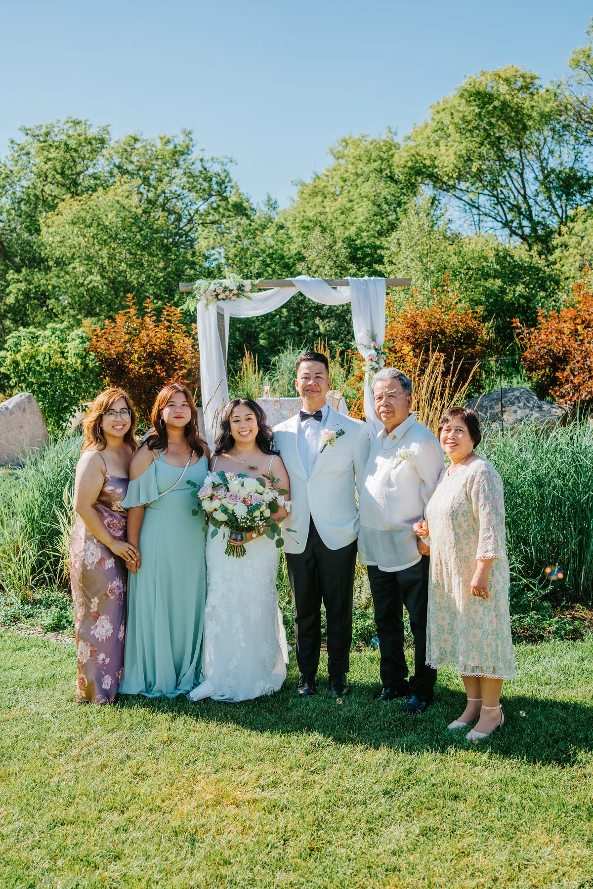 Jay and Mark walking the recessional aisle surrounded by bubbles — just married at Hawthorne Estates, Manitoba