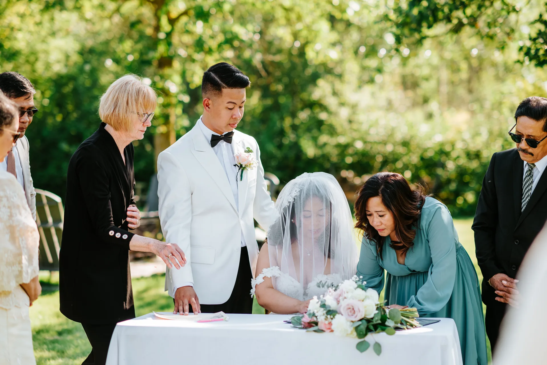 Jay and Mark signing the marriage licence at the outdoor ceremony table at Hawthorne Estates, Manitoba