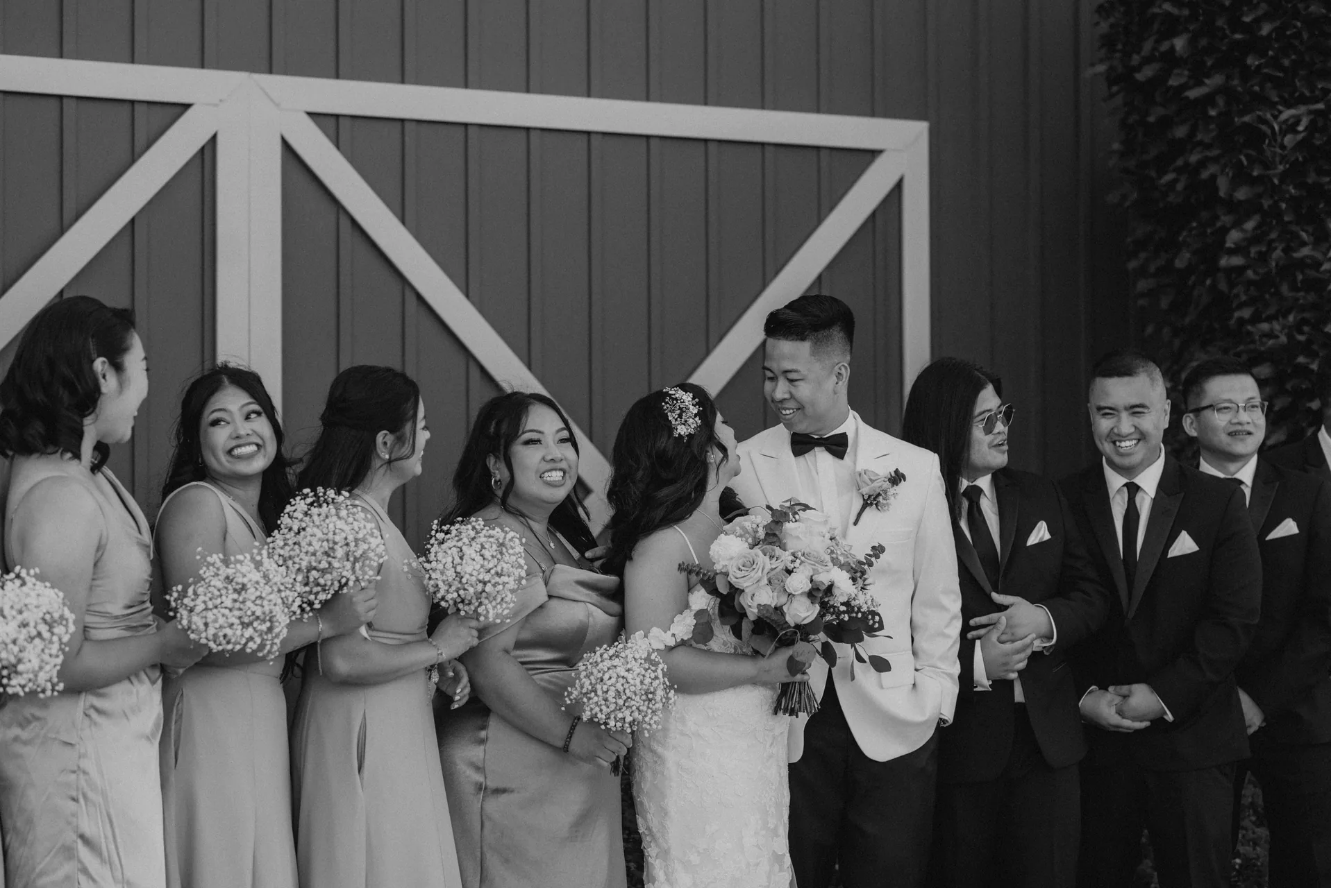 Wedding party portrait against the Hawthorne Estates barn doors in black and white, Manitoba