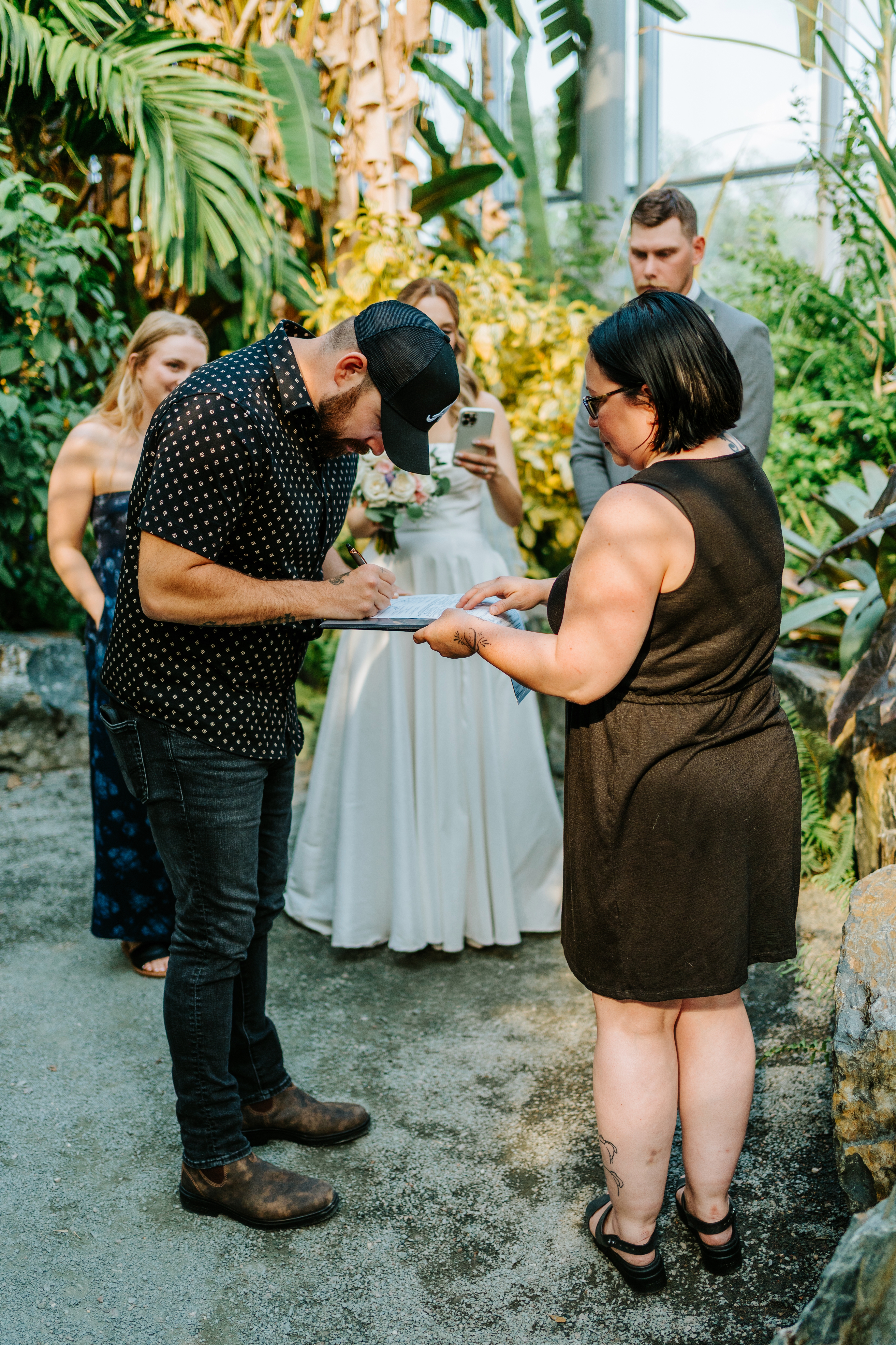 Witness signing the marriage certificate during Liam and Tanya's intimate wedding ceremony inside The Leaf Assiniboine Park — documentary wedding photography by Ngo Photography