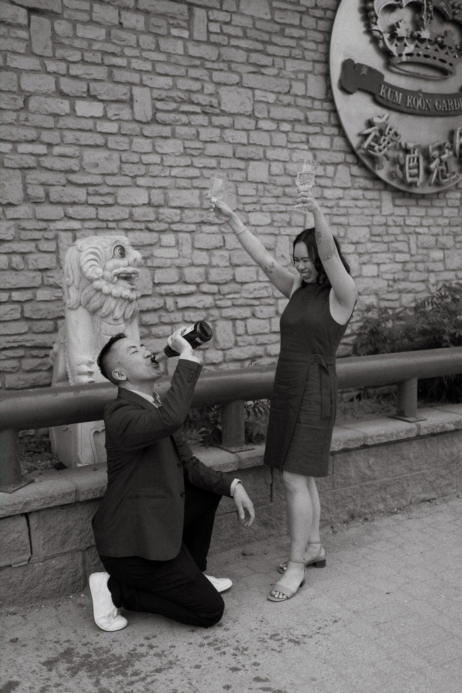 Monica and Jason black and white champagne toast outside Kum Koon Garden Winnipeg — Chinese Vietnamese engagement session final frame by Ngo Photography